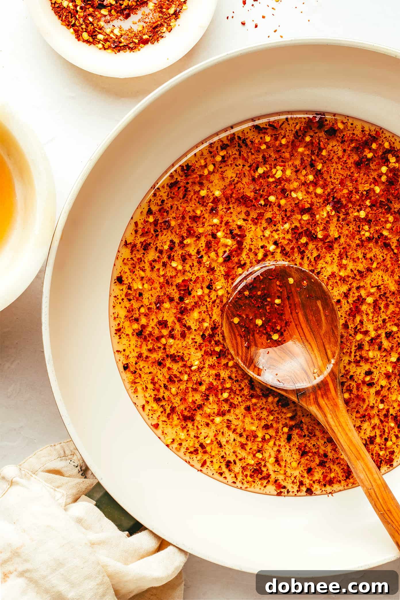 This homemade hot honey recipe is quick and easy to make with 3 ingredients and tastes delicious drizzled on everything from pizza to biscuits, fried chicken, salmon, veggies, baked brie and more! | gimmesomeoven.com Making homemade hot honey recipe in saute pan, infusing chili flakes