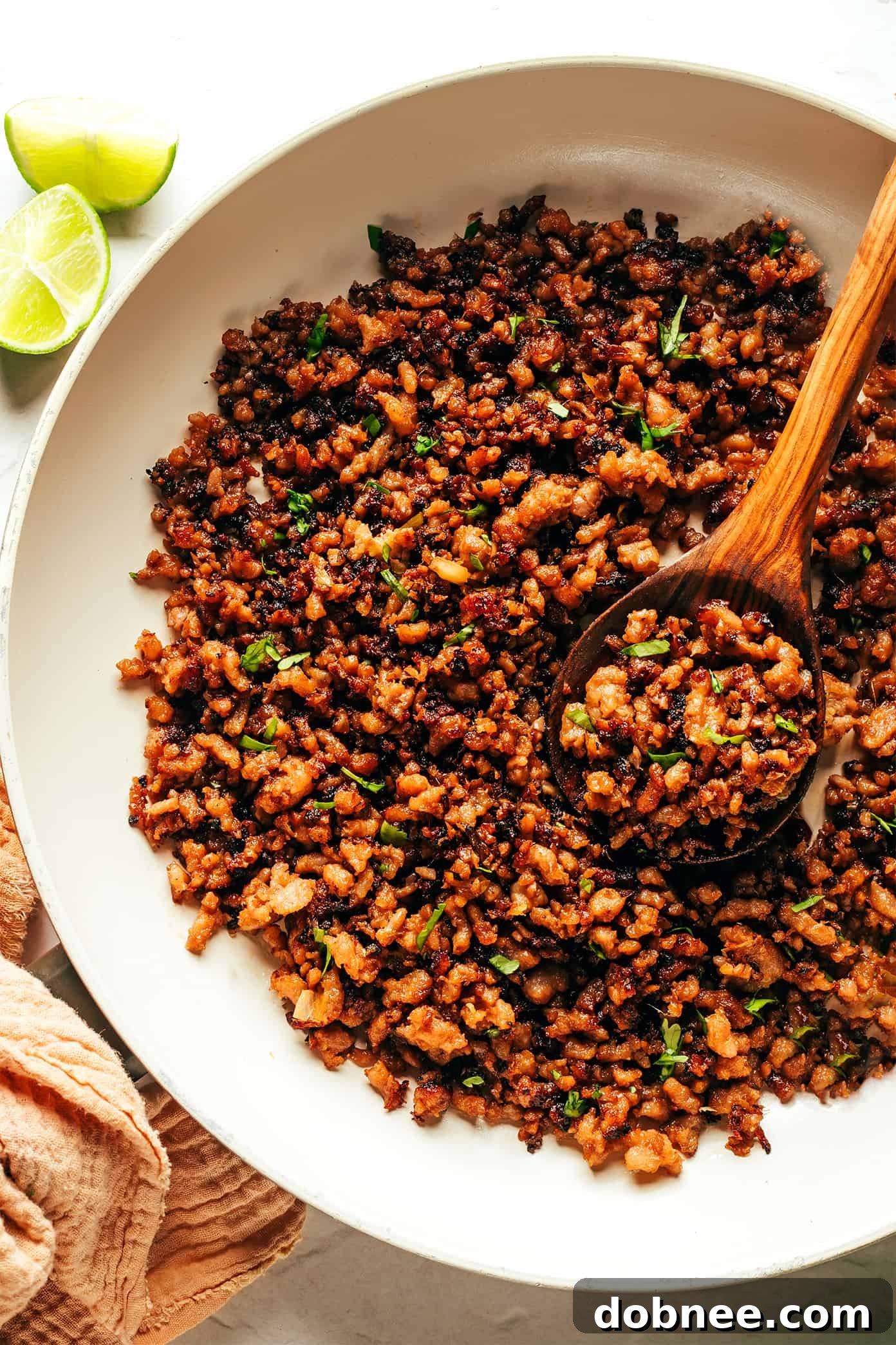 Ground pork caramelizing in a sauté pan with the ginger-lime sauce, creating a sticky glaze.