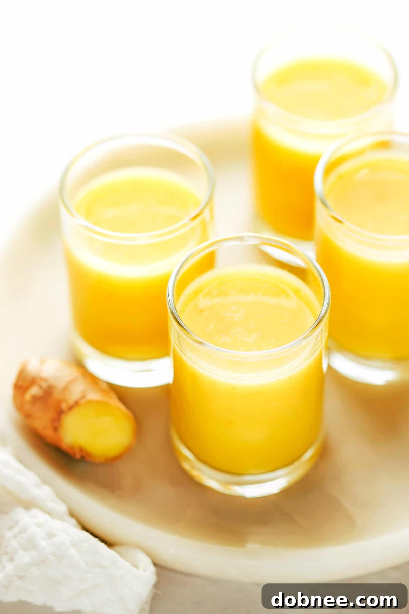 Freshly blended ginger shots in small glasses, ready to drink.