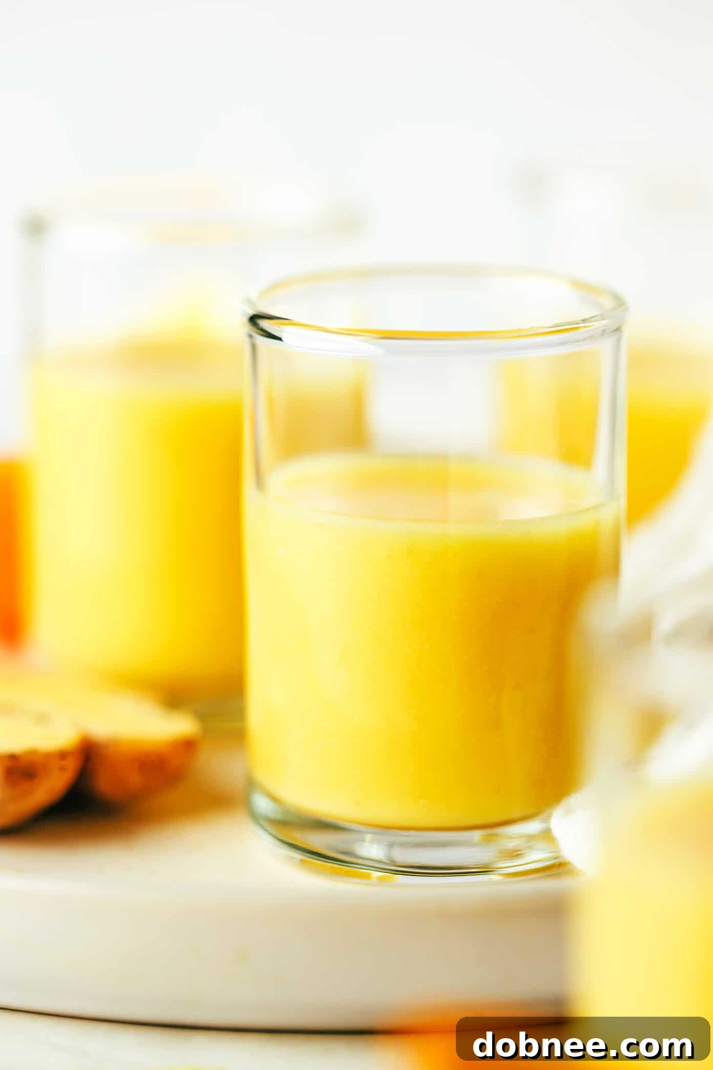 Closeup of a vibrant ginger shot in a glass, showcasing its rich golden color.