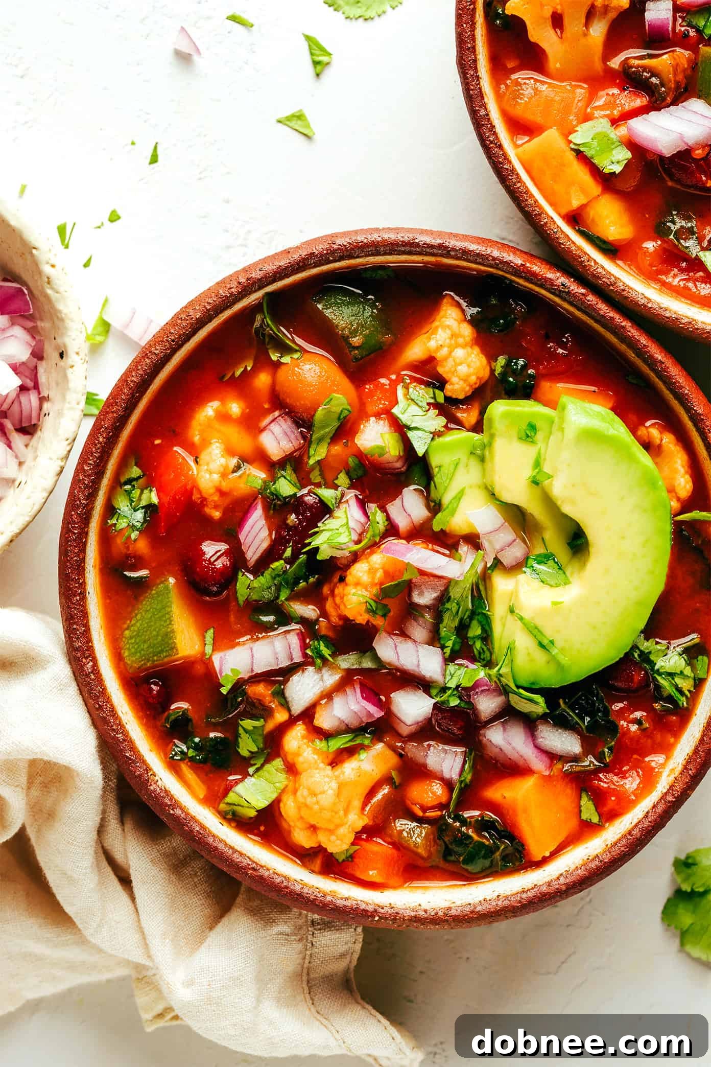 Extra-Veggie Vegetarian Chili with Avocado, packed with beans and a variety of vegetables like sweet potato, bell pepper, zucchini, mushrooms, and cauliflower. A naturally gluten-free and vegan soup recipe that is highly customizable and always incredibly delicious.