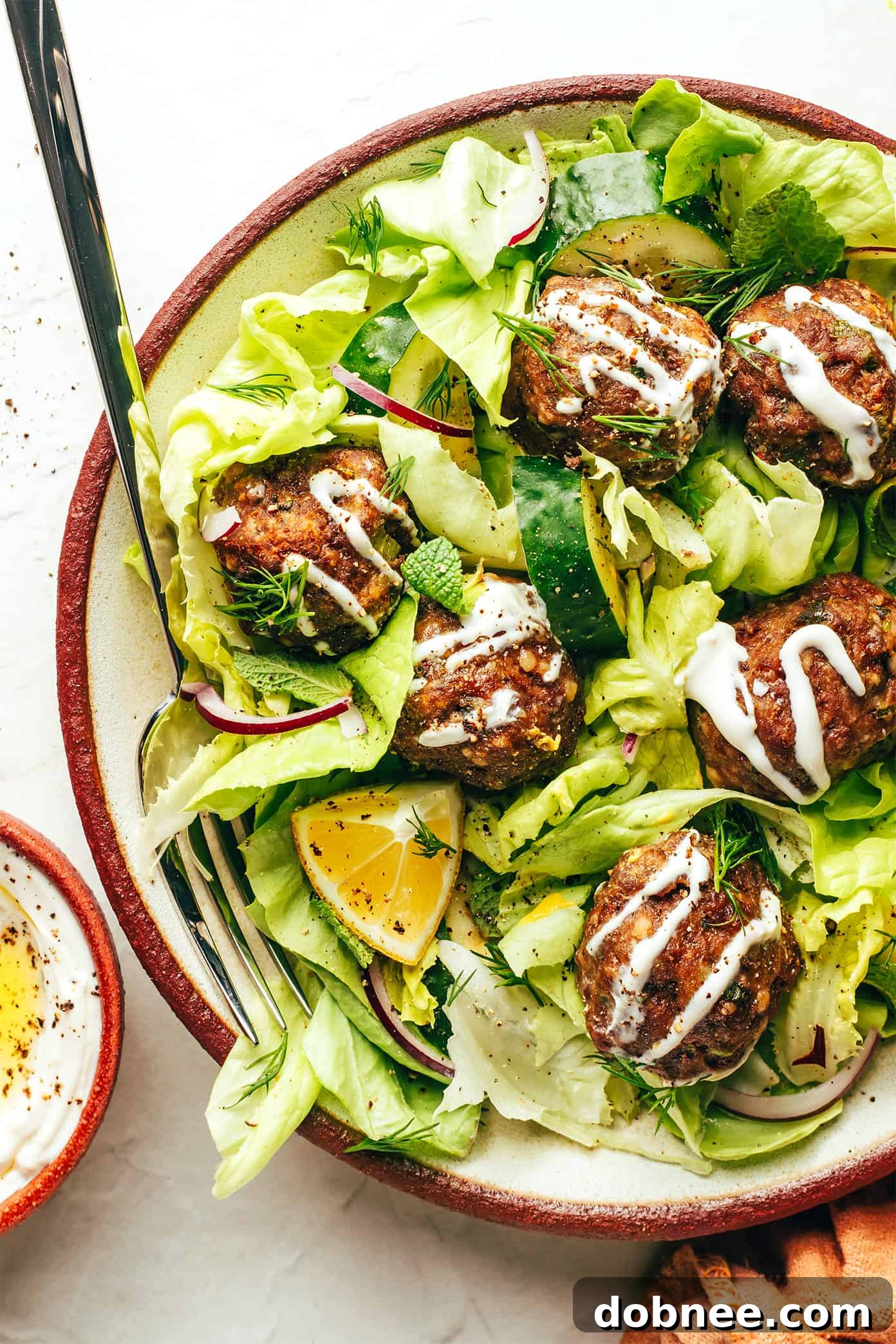 Close-up of Greek meatballs on a plate with fresh lemon and herbs