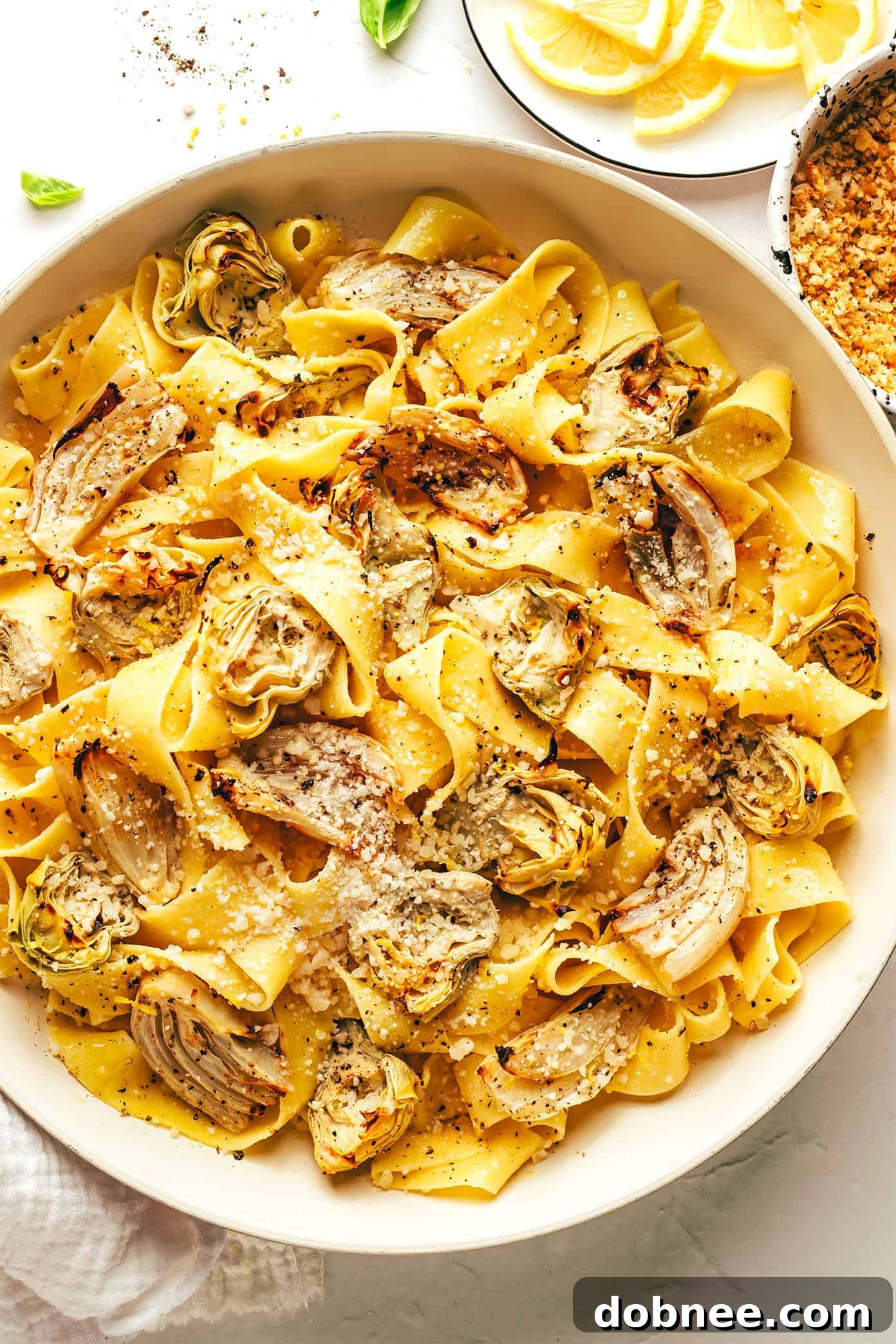 Lemon Brown Butter Pasta served in a skillet, brimming with roasted artichokes and fennel, and generously garnished with garlic breadcrumbs.