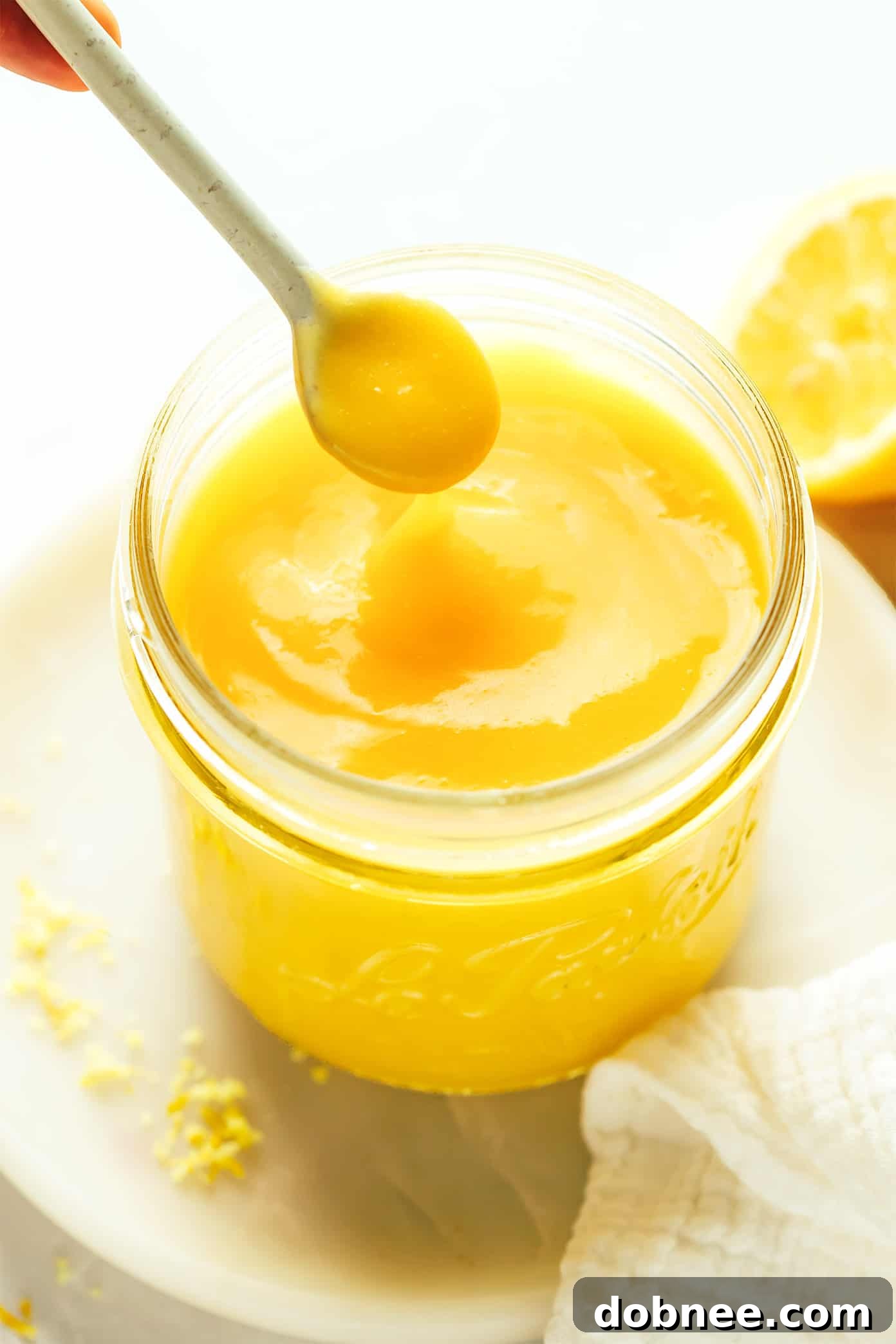 A beautifully presented jar of homemade lemon curd, showcasing its vibrant yellow color and smooth texture. Perfect for spreading or as a delicious filling.