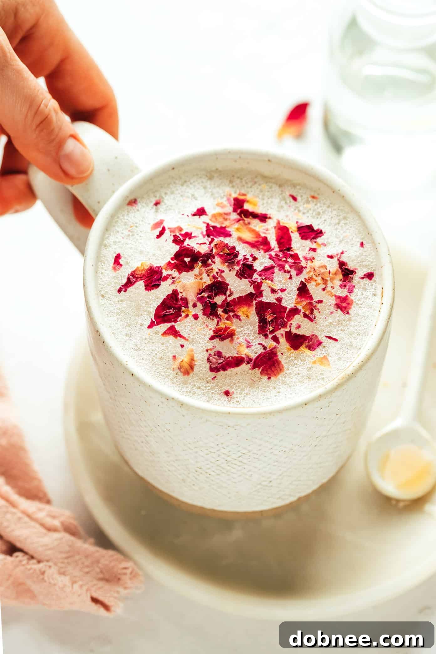 Velvet Rose Latte 2 A beautifully crafted vanilla rose latte in a delicate glass cup, garnished with dried rose petals.