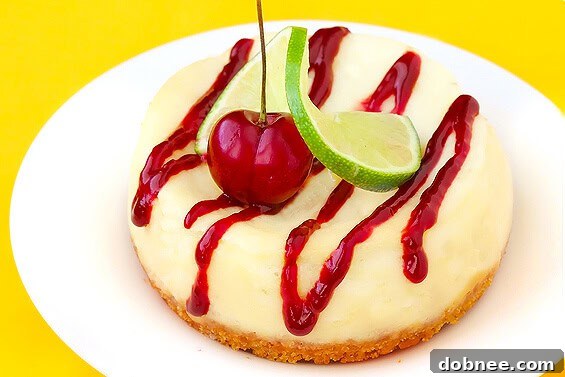 A slice of vibrant cherry limeade cheesecake with a bright pink filling and a crumbly crust.