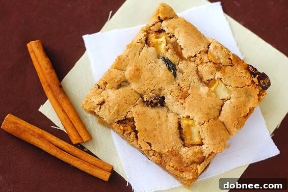 Warm, golden-brown apple cinnamon raisin bars, fresh from the oven, ready to be enjoyed.