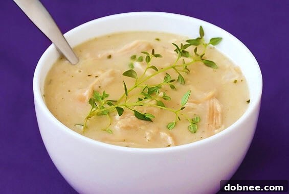A rich and aromatic bowl of 44-clove garlic and chicken soup, garnished with fresh herbs.