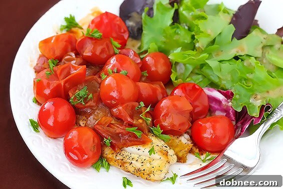 Flaky tilapia fillets served with a vibrant tomato-herb pan sauce and fresh greens.