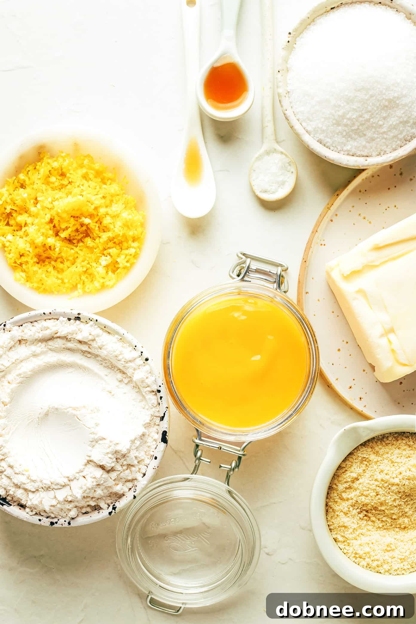 Ingredients for homemade Lemon Thumbprint Cookies including flour, butter, sugar, lemon, and extracts