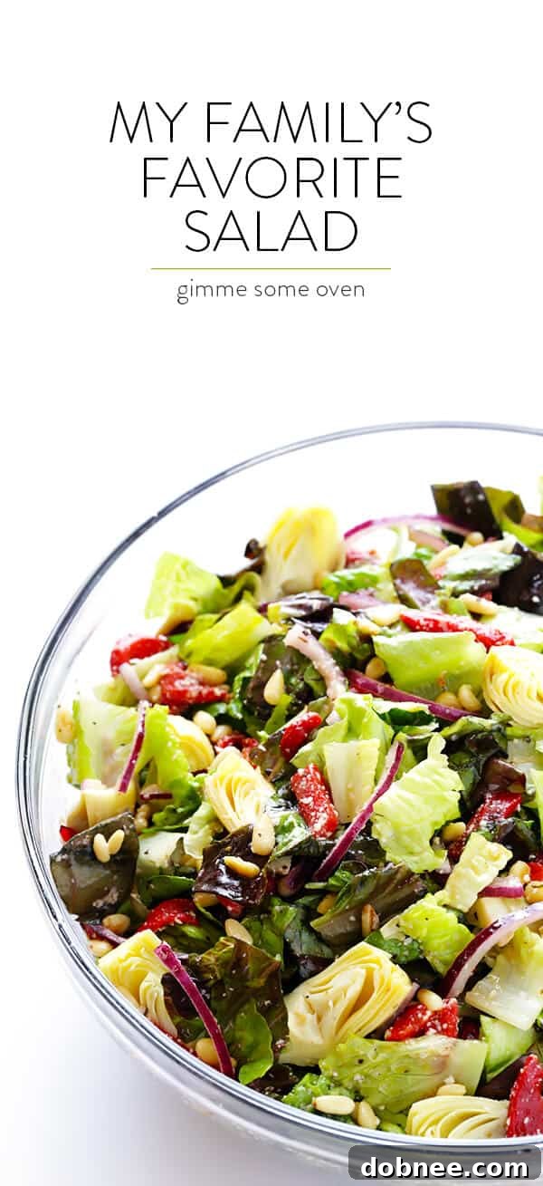 Our Family's Favorite Salad is made with lots of artichoke hearts, roasted red peppers, toasted pine nuts, and a zesty Parmesan vinaigrette. SO delicious, and always a crowd pleaser! | gimmesomeoven.com