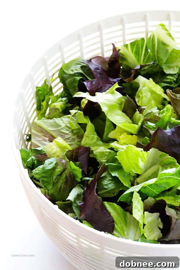 Our Family's Favorite Salad is made with lots of artichoke hearts, roasted red peppers, toasted pine nuts, and a zesty Parmesan vinaigrette. SO delicious, and always a crowd pleaser! | gimmesomeoven.com