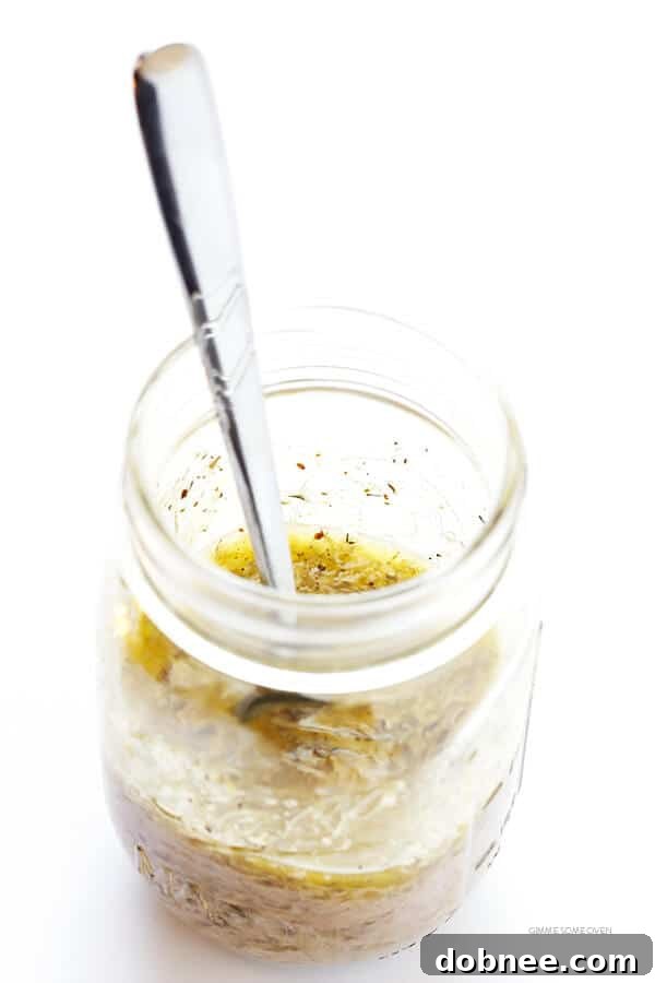 Our Family's Favorite Salad is made with lots of artichoke hearts, roasted red peppers, toasted pine nuts, and a zesty Parmesan vinaigrette. SO delicious, and always a crowd pleaser! | gimmesomeoven.com