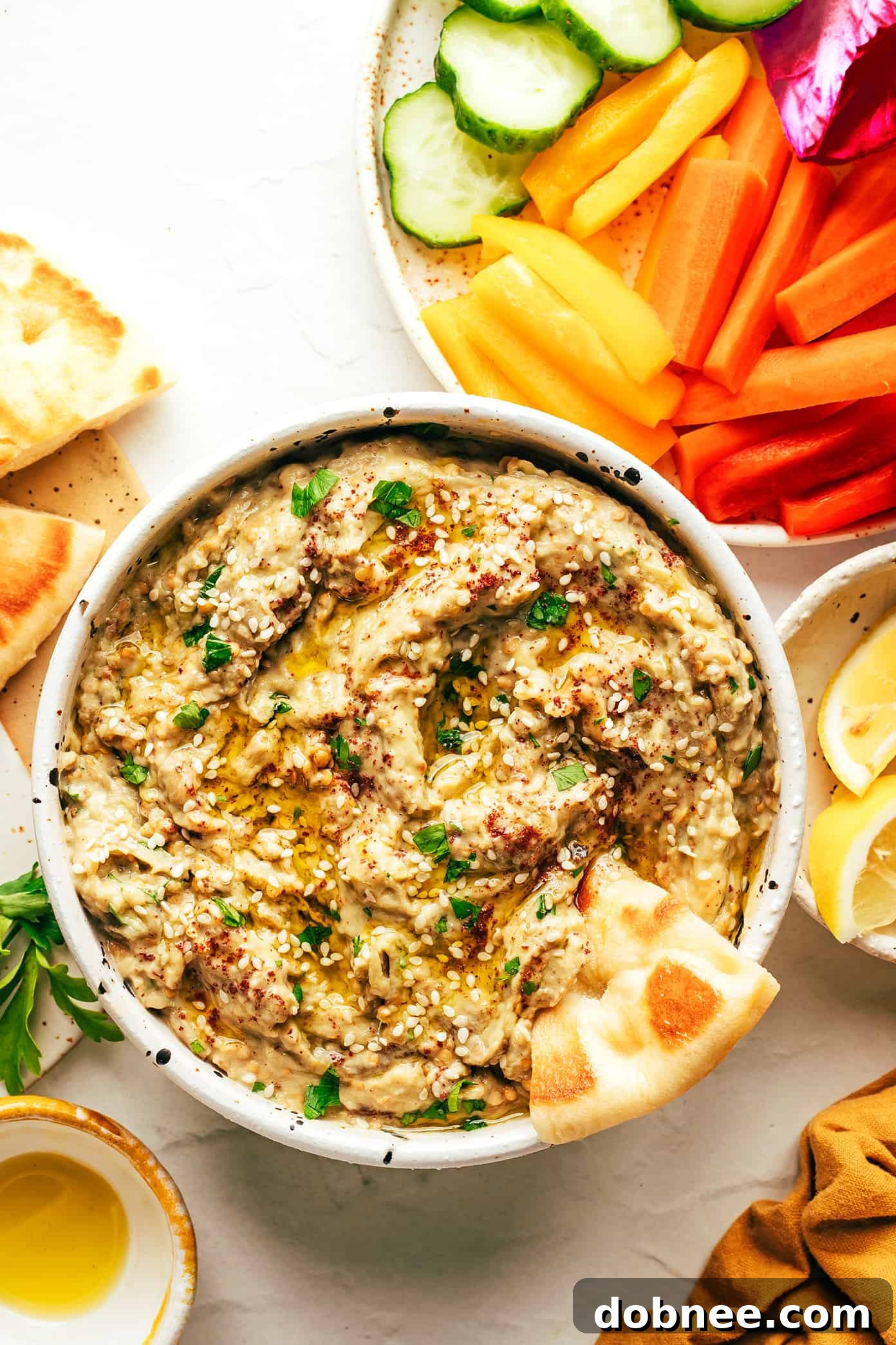 A vibrant bowl of baba ganoush garnished with fresh herbs and a drizzle of olive oil, ready to be served.