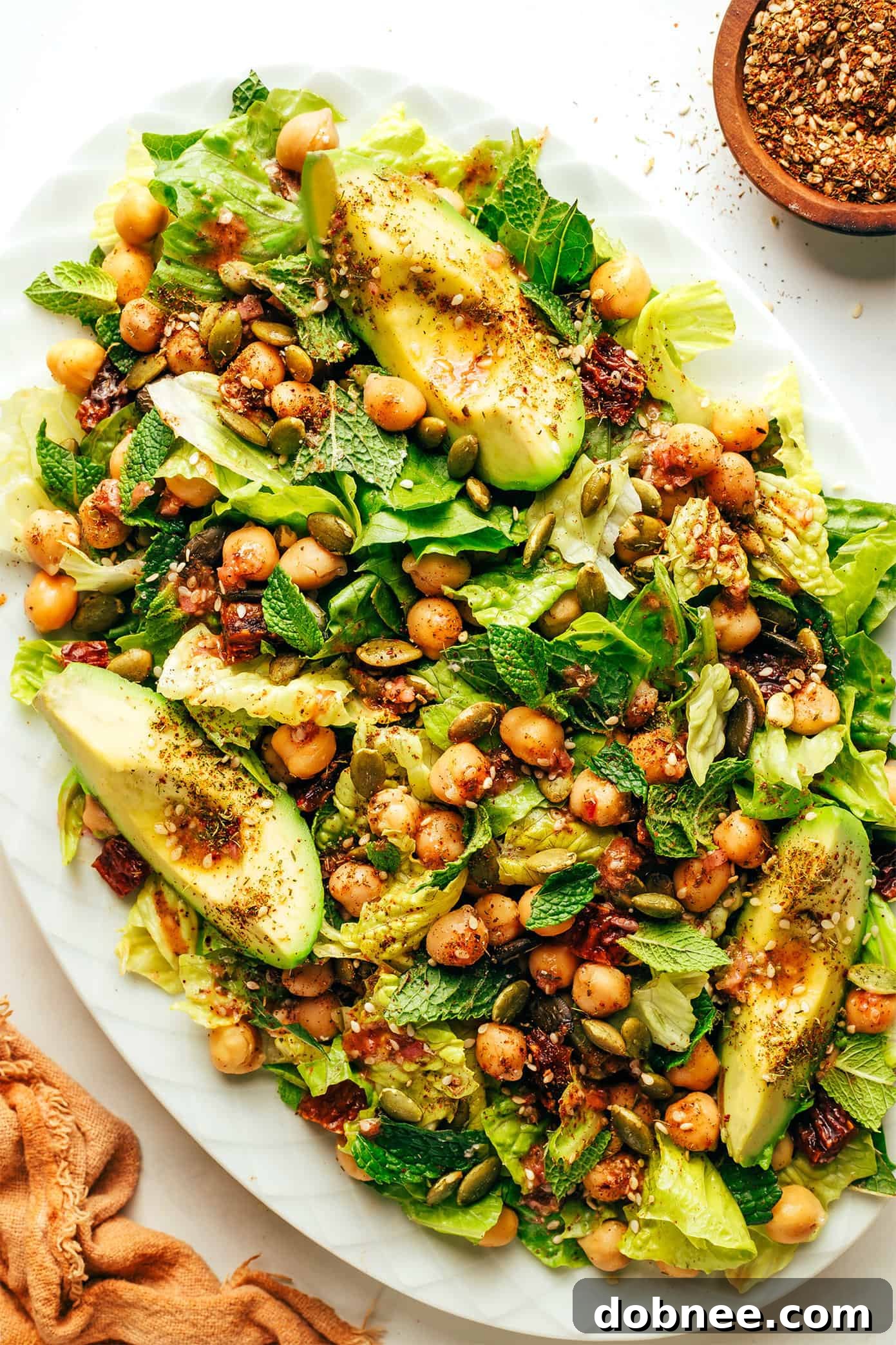 Large serving platter overflowing with the vibrant Chickpea, Date, and Avocado Salad, ready to be shared.