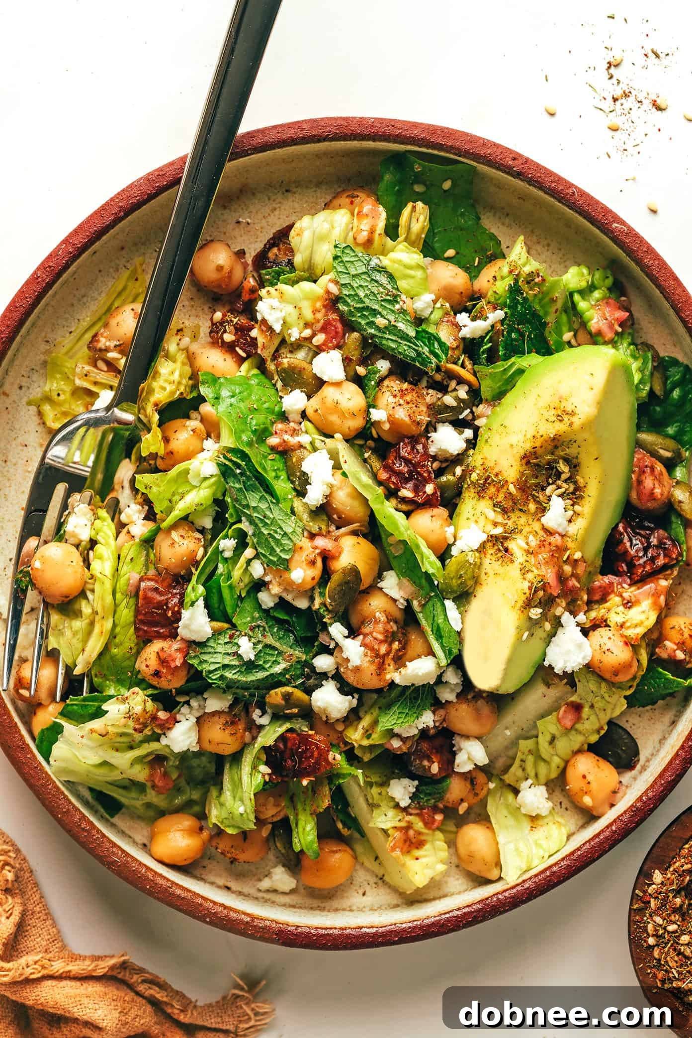 Close-up of a single serving bowl of Chickpea, Date, and Avocado Salad with Za'atar Vinaigrette, ready to be enjoyed.