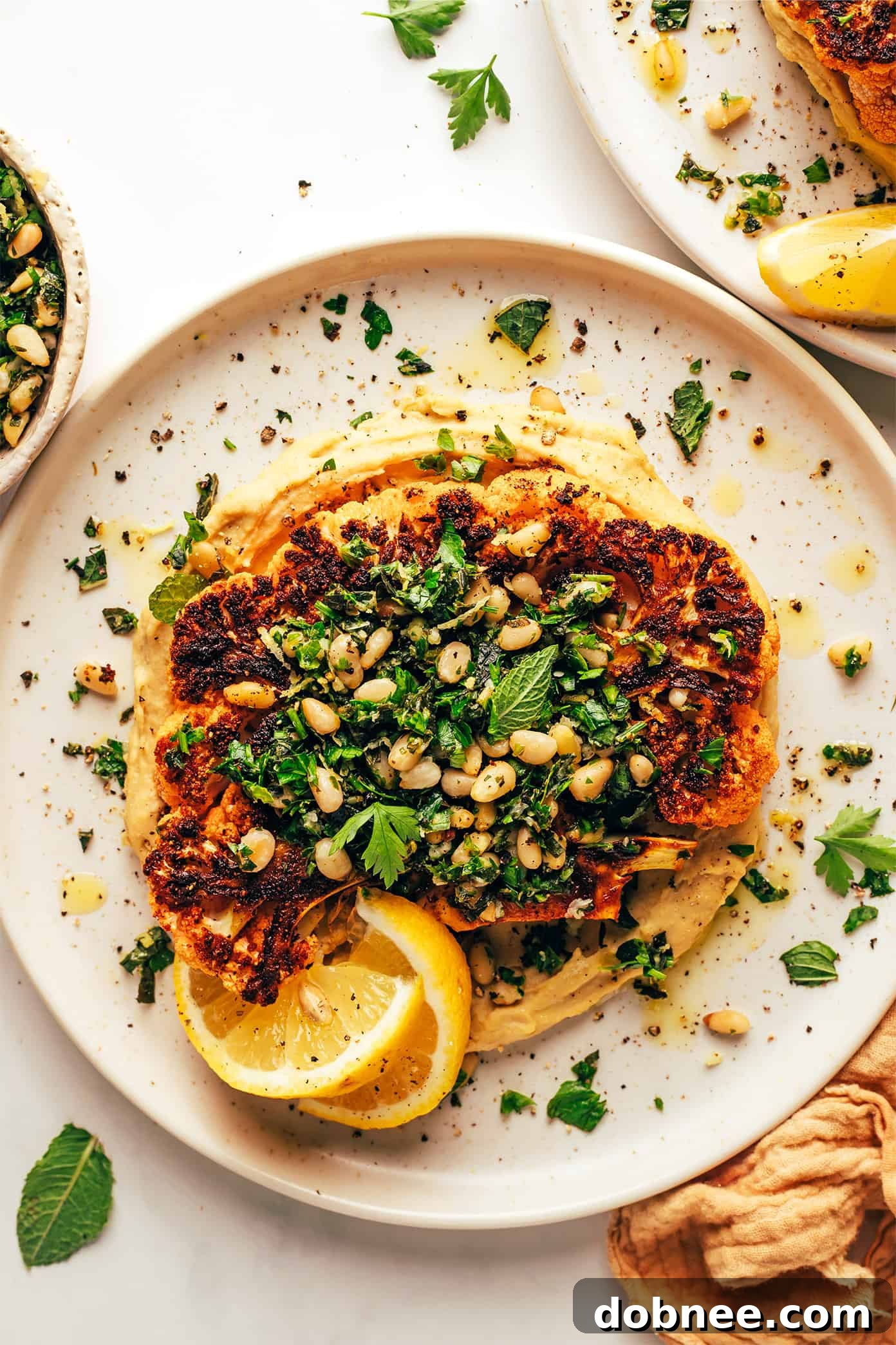 Close-up of Cauliflower Steaks with Hummus and Gremolata on serving plates