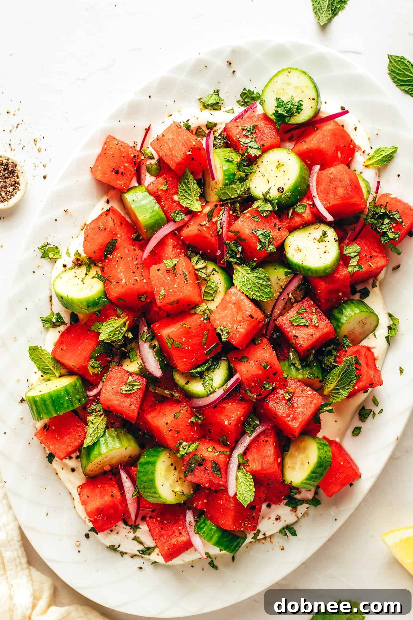 Vibrant Watermelon Feta Salad with Whipped Feta as a base, garnished with fresh mint