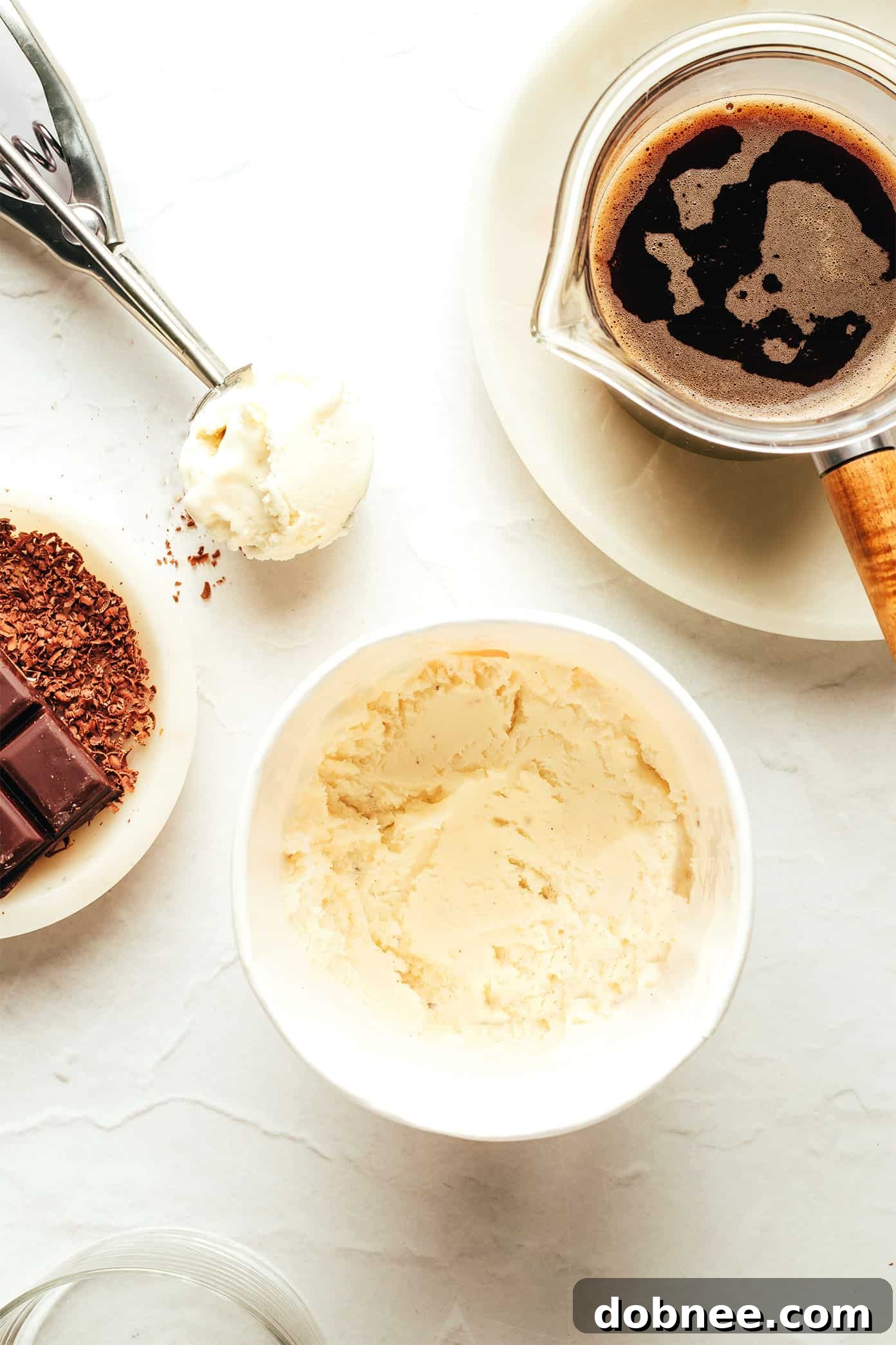 A close-up of a spoon digging into a melting affogato, showing the rich espresso swirling with vanilla ice cream.