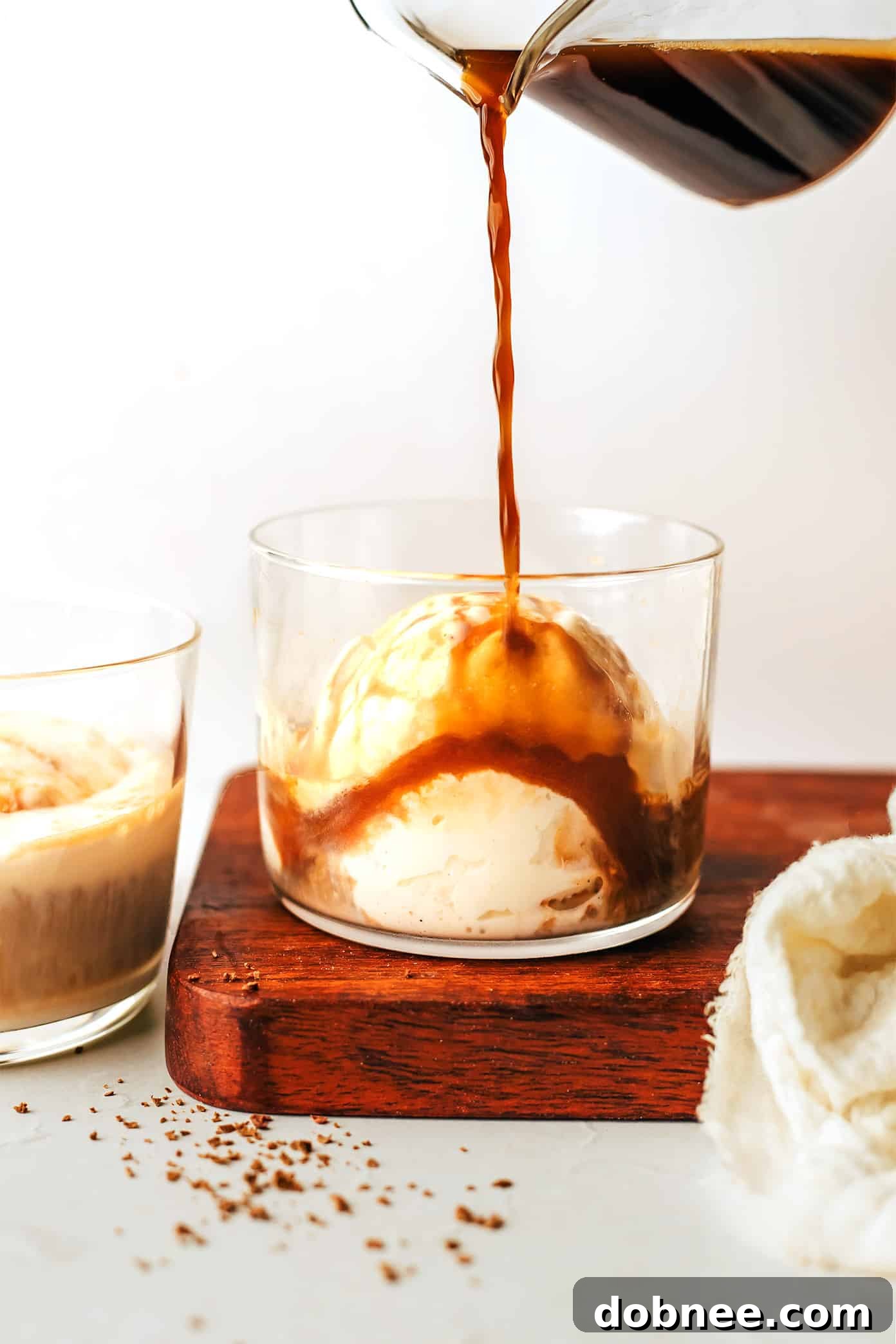 Two glasses of affogato, one with chocolate shavings and the other with a plain, creamy espresso over ice cream.
