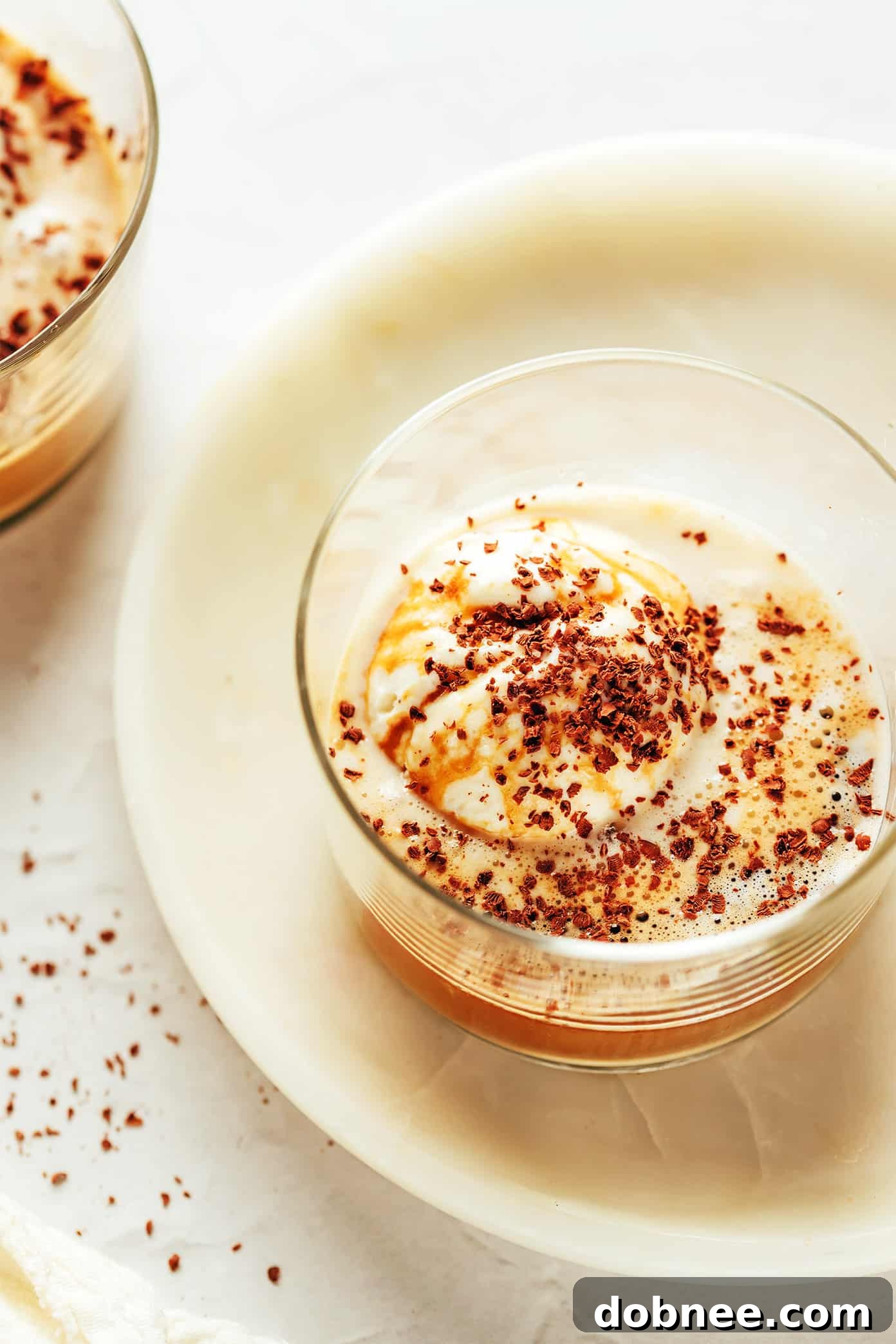 A close-up of a serving of white chocolate affogato with delicate white chocolate shavings on top.