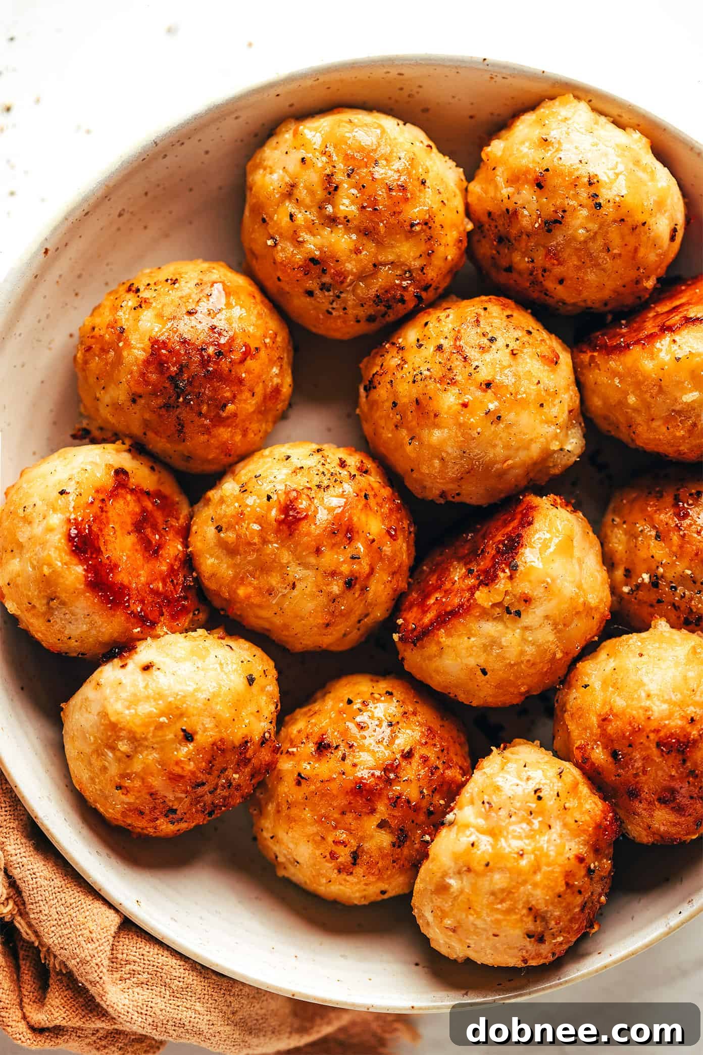 Close-up of a baked chicken meatball on a fork