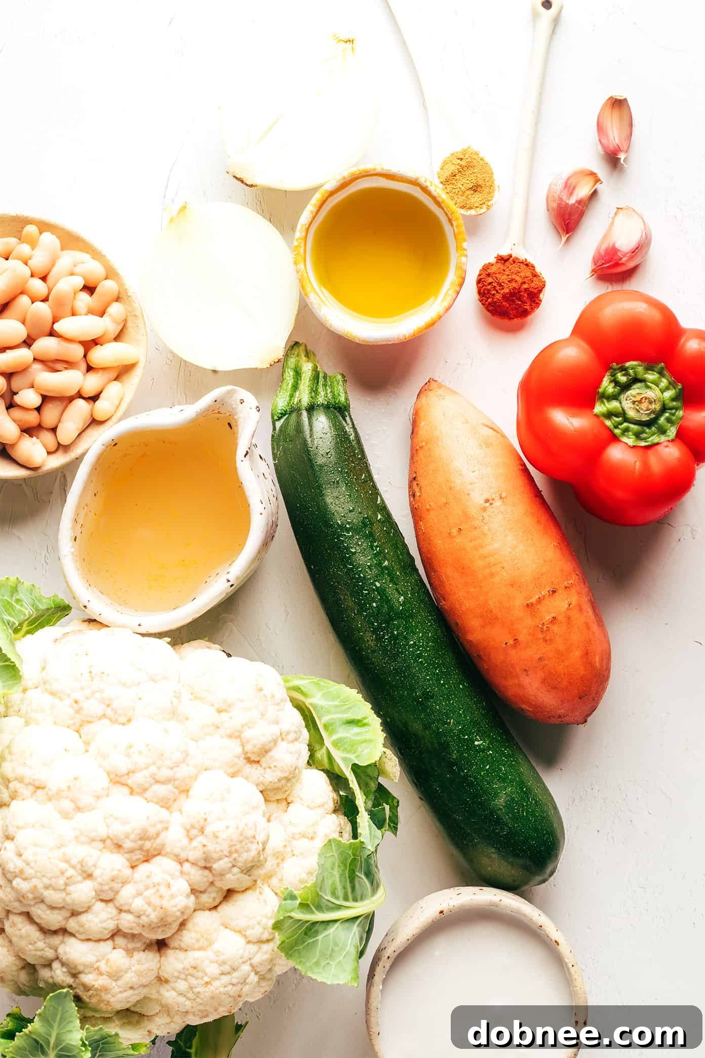 Velvety Vegetable Medley 3 A close-up of vibrant, diced vegetables including bell pepper, sweet potato, cauliflower, and onion, ready for roasting.