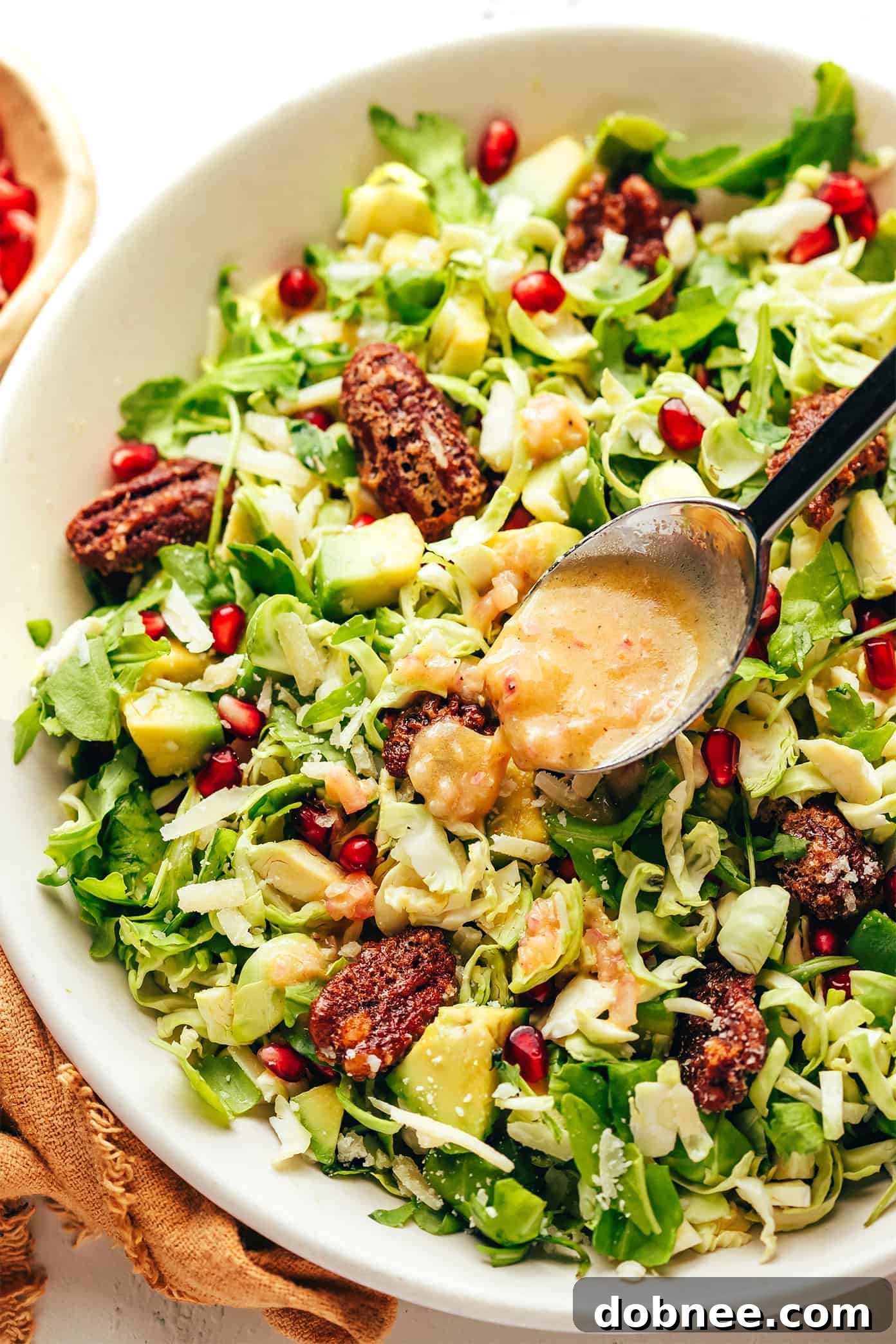 Brussels Sprouts Arugula Salad with Pomegranate and Parmesan, served in a bowl
