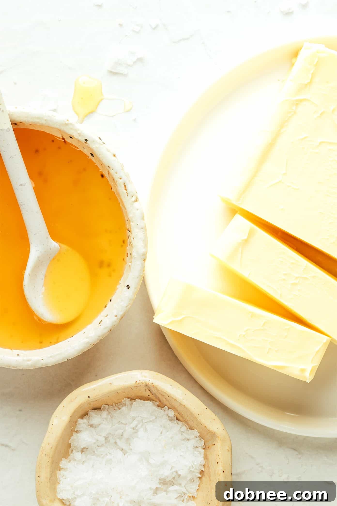 A wooden spoon scooping creamy honey butter from a bowl, highlighting its smooth texture