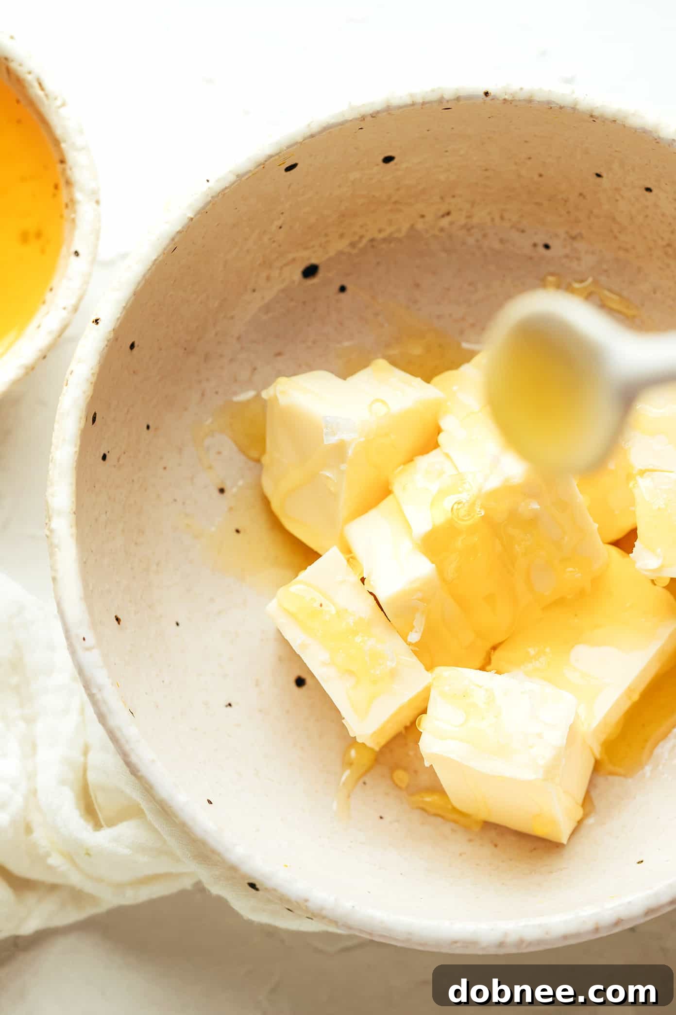 A close-up of a bowl of whipped honey butter, showing its creamy texture and a subtle swirl pattern