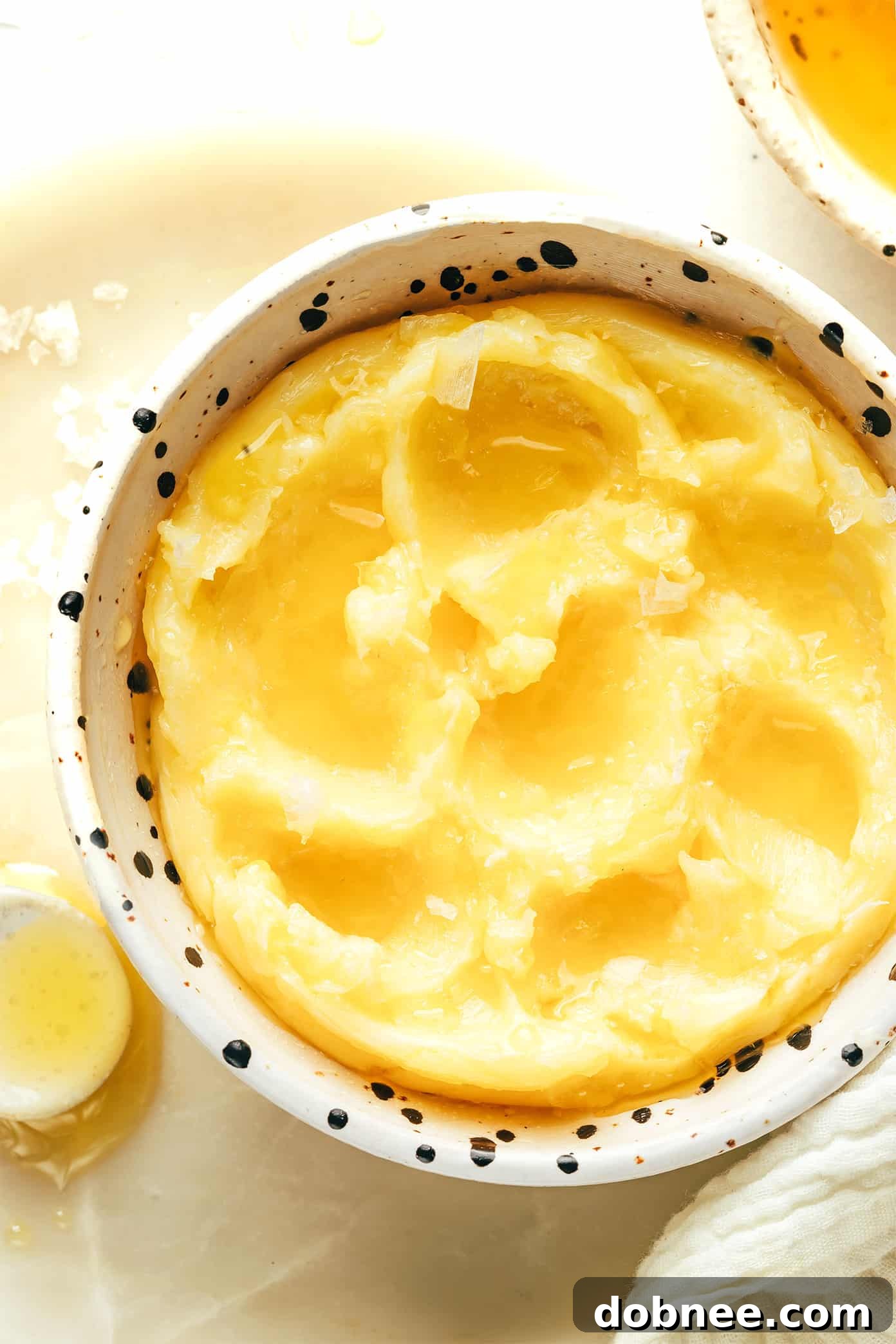 Five small bowls of different honey butter variations: original, garlic-herb, spicy, cinnamon, and citrus