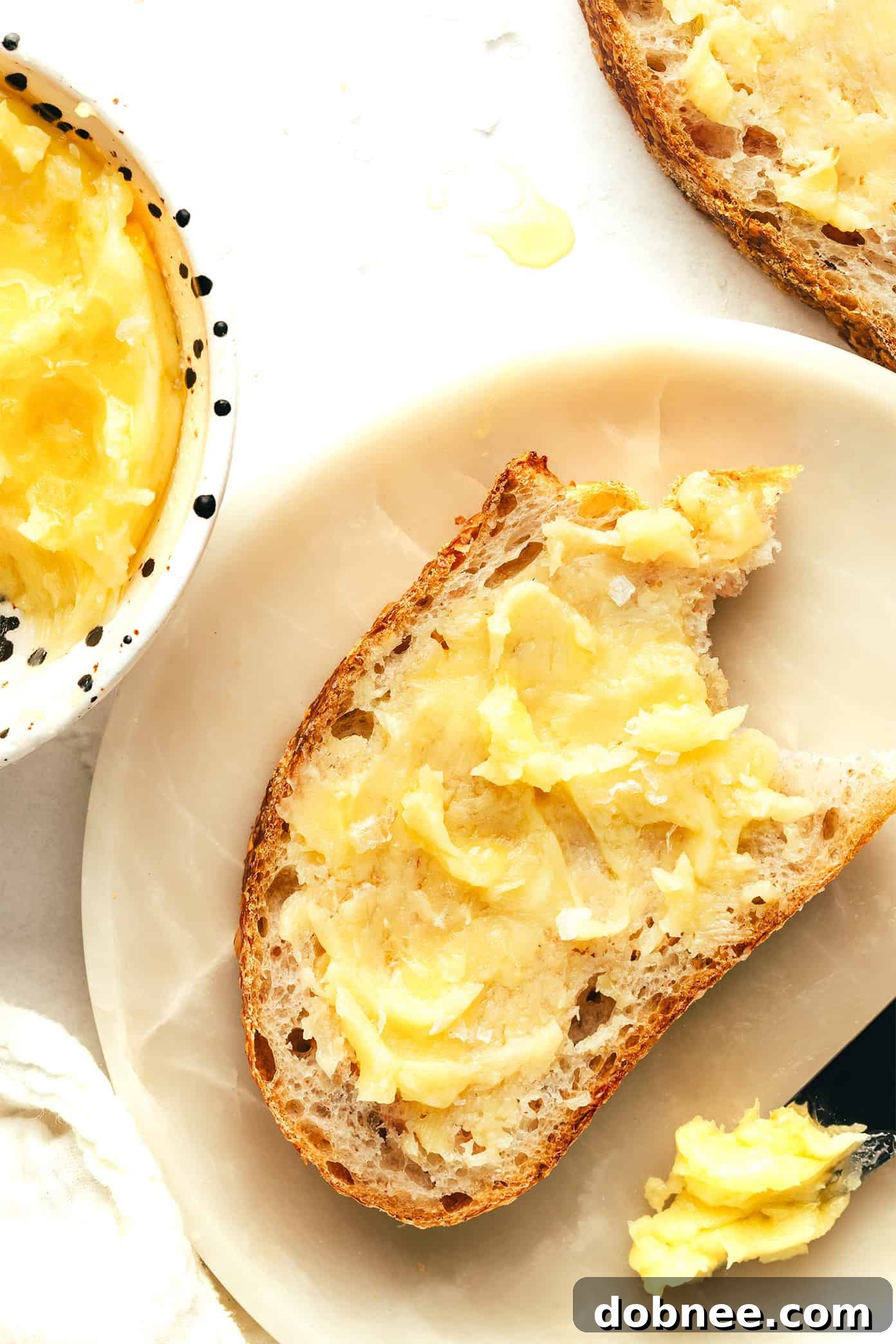 A close-up of a serving of warm cornbread with a dollop of honey butter melting on top