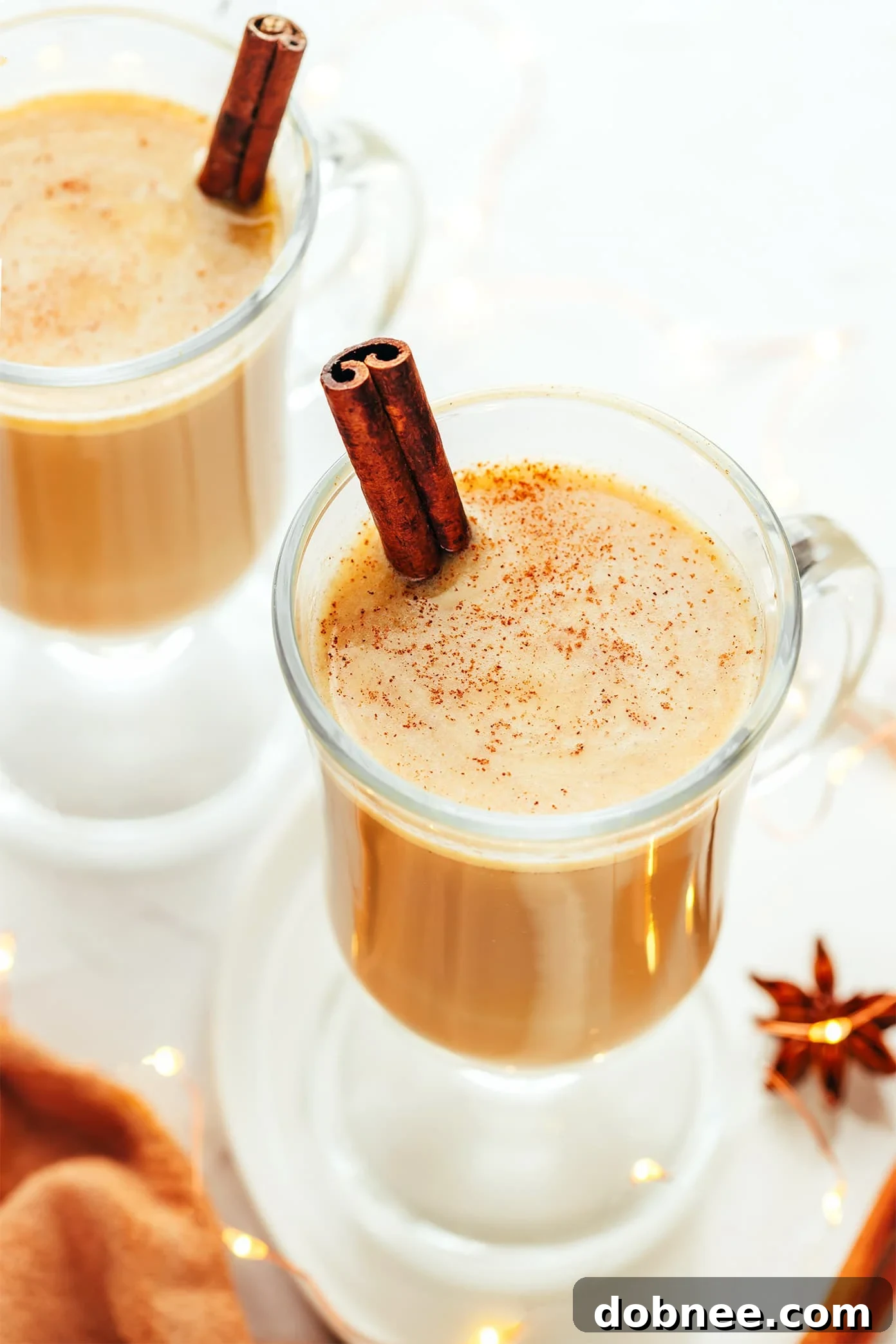 A steaming mug of hot buttered rum, garnished with a cinnamon stick, evokes warmth and comfort on a cold winter's night.