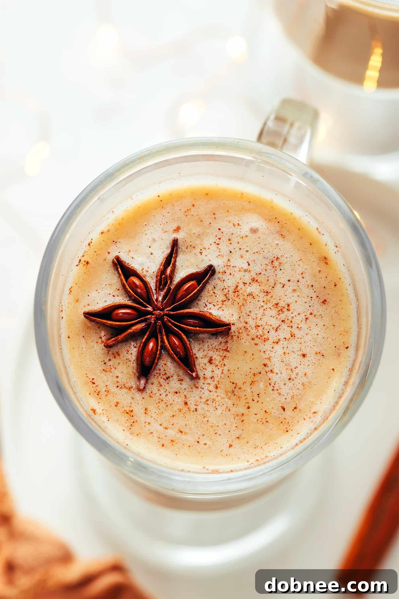 Five glasses of hot buttered rum, each garnished differently, showing various presentation styles.