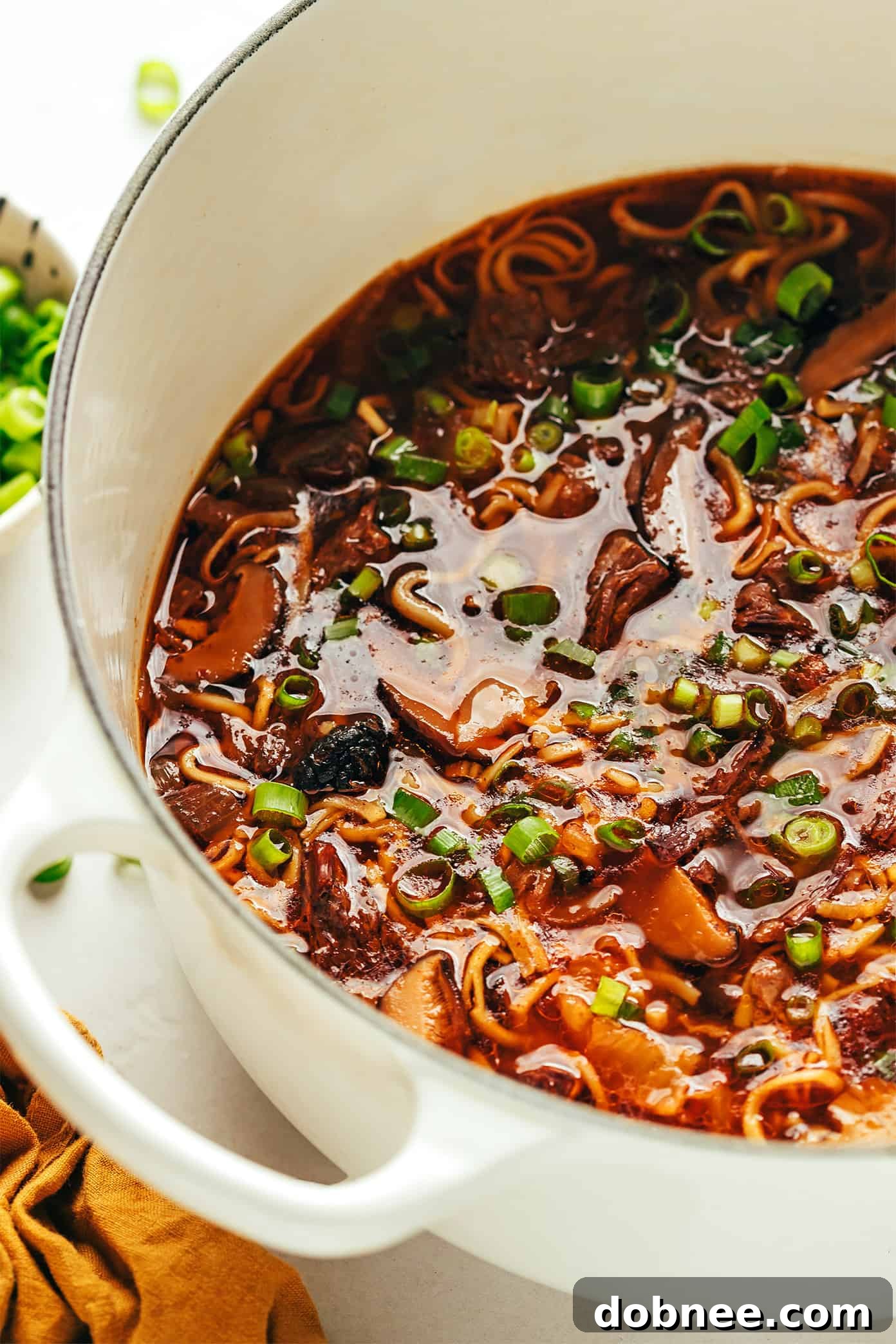 A delicious bowl of Kimchi Beef Noodle Soup with tender beef, noodles, and green onions