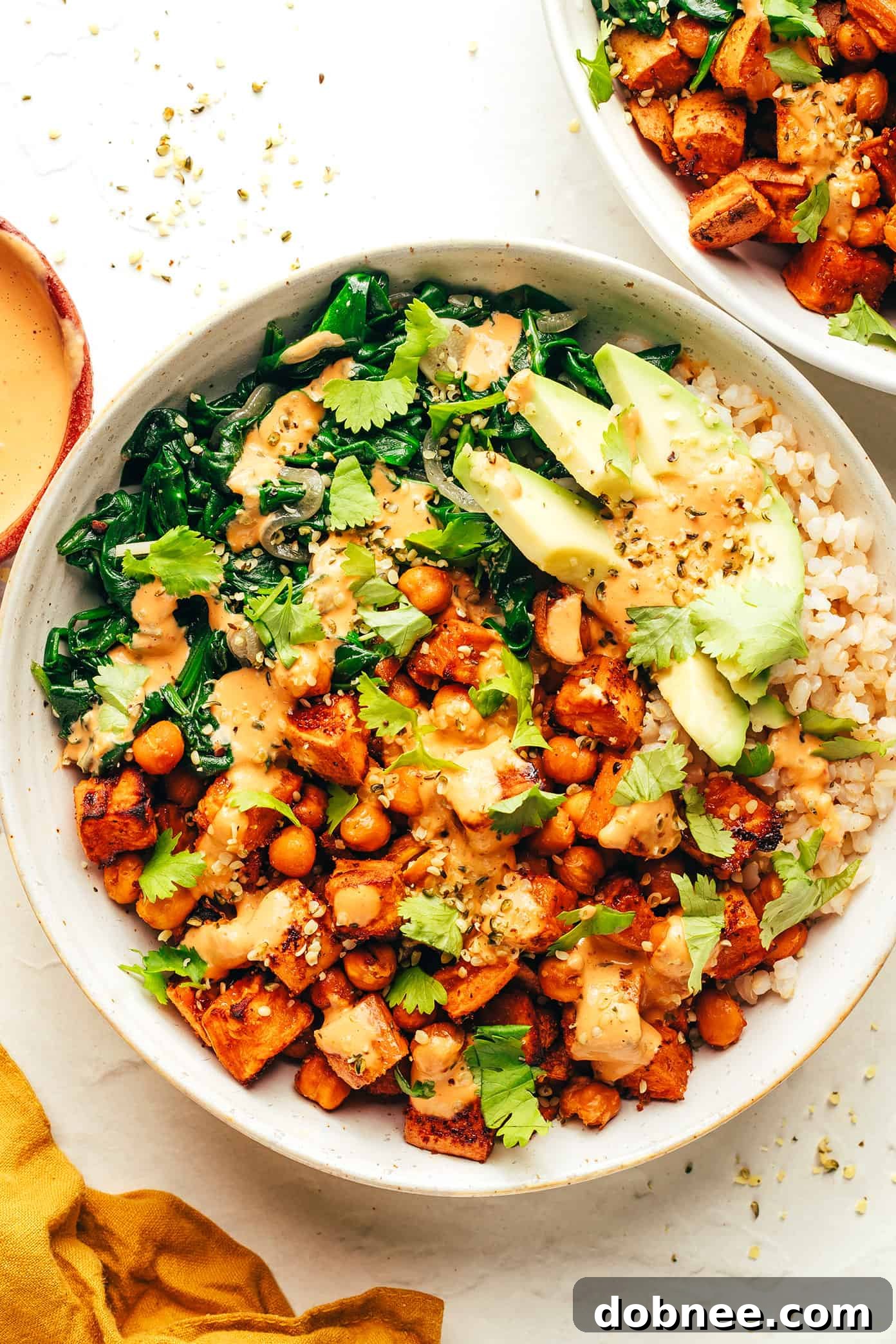 A close-up shot of the finished sweet potato and chickpea bowls, garnished with fresh cilantro.