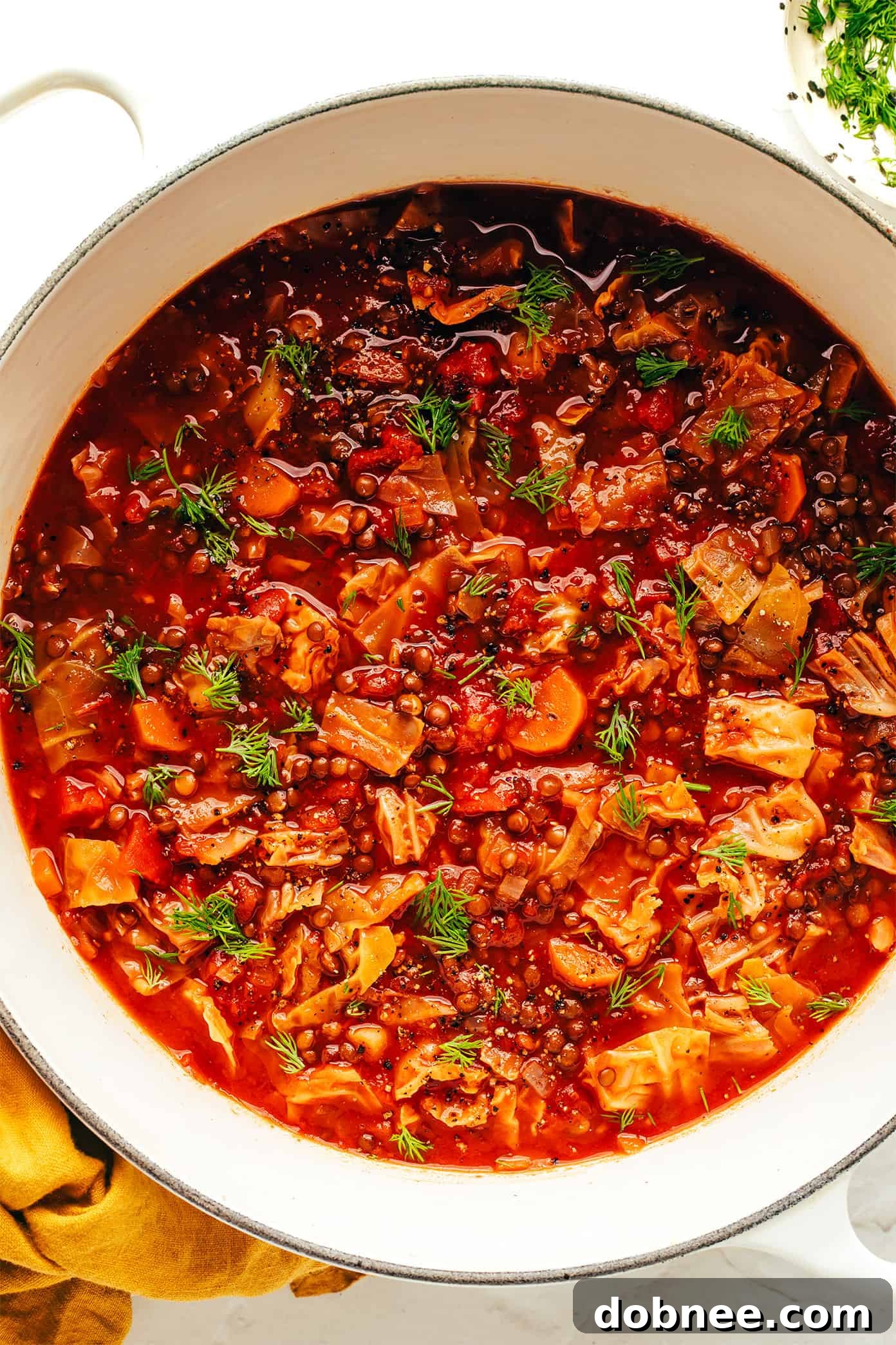 A large pot of Vegetarian Cabbage Roll Soup simmering on the stove.
