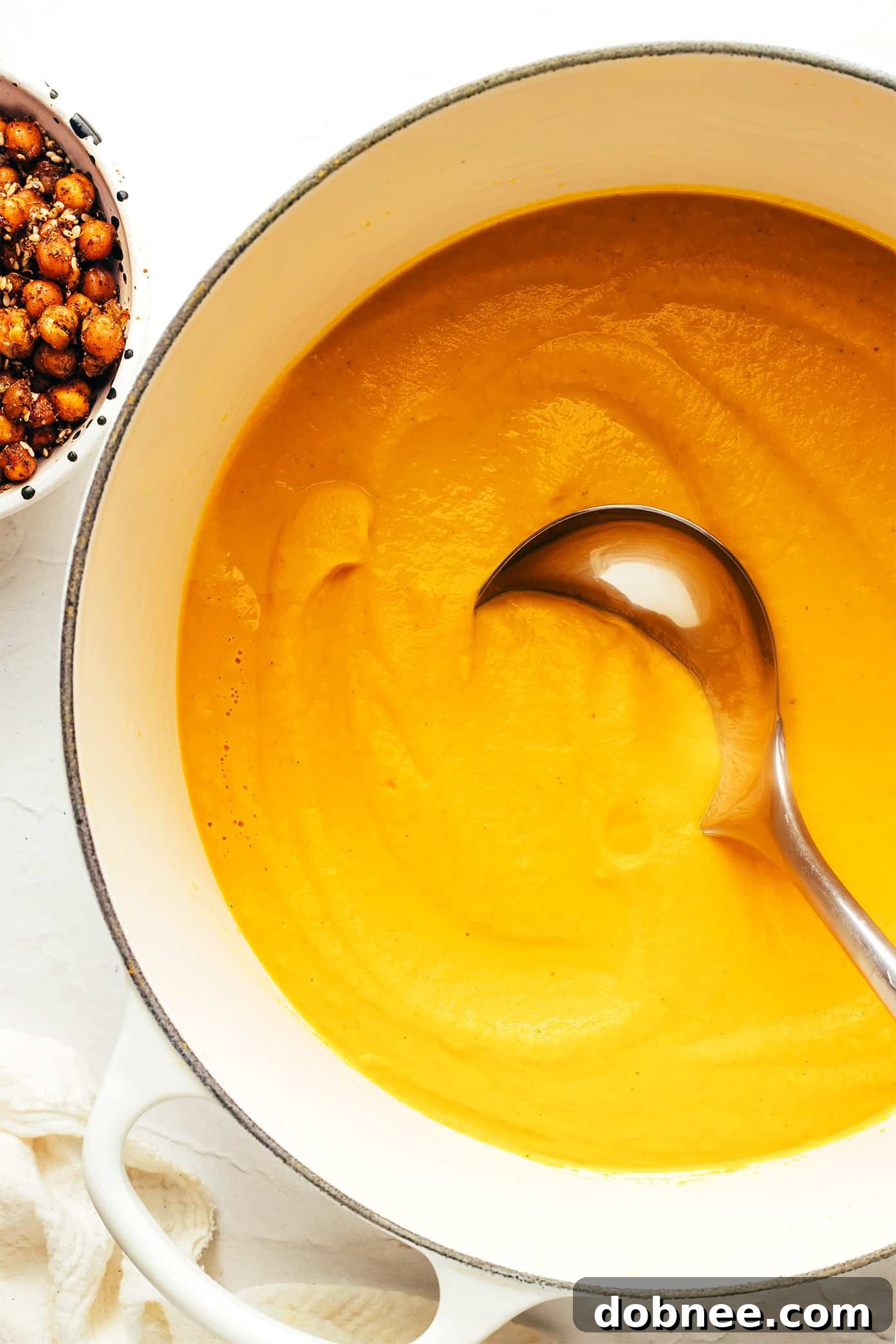 A spread of various ingredients including carrots, chickpeas, and fresh herbs, ready for making soup.
