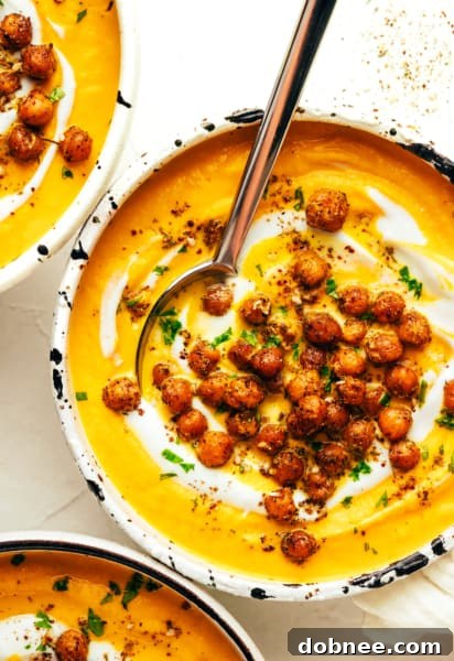 A bowl of creamy roasted carrot soup garnished with za'atar chickpeas.