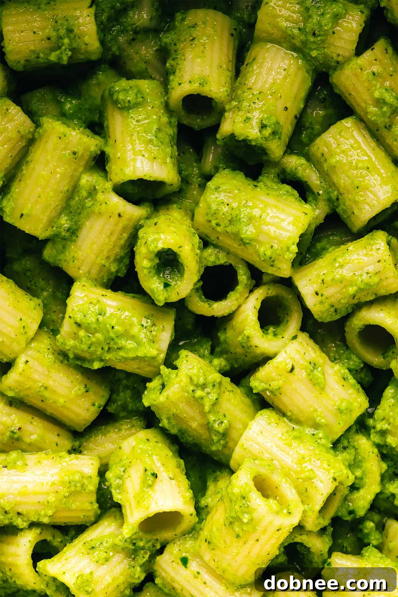 A close-up of Lemony Broccoli Pesto Pasta with a fork, showing the texture and fresh ingredients.