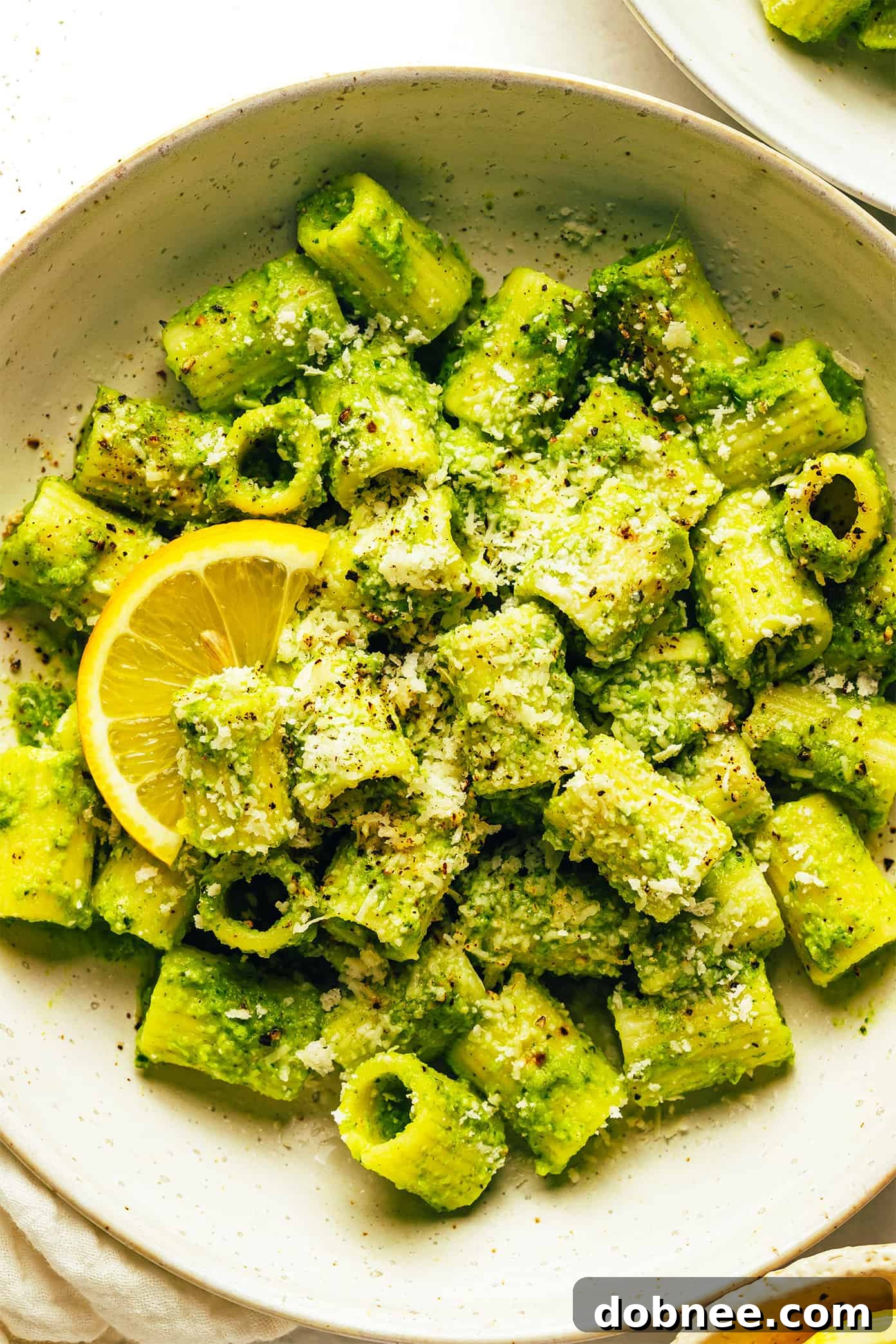 A final close-up of the Lemony Broccoli Pesto Pasta, ready to be served, with a sprinkle of cheese.