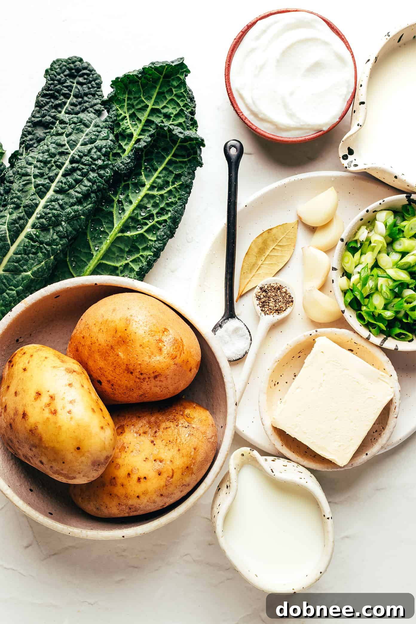 Close-up of fluffy Colcannon in a white bowl, showing creamy texture and visible pieces of kale.