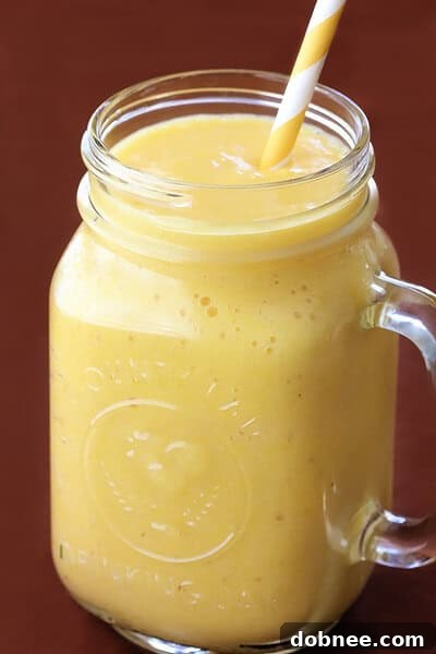 Close-up of a refreshing Pineapple Ginger Smoothie, showing its creamy texture and bright yellow color