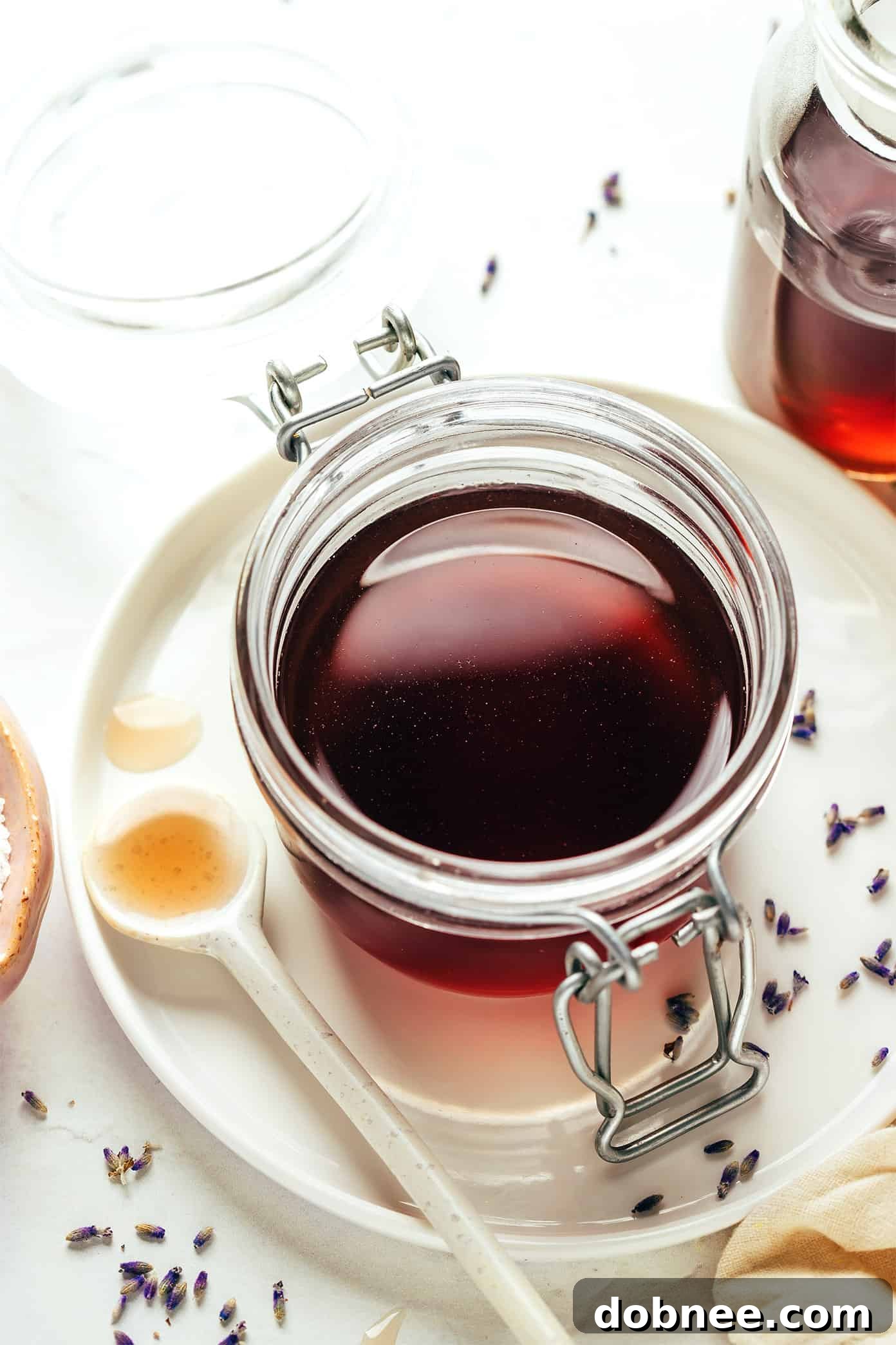 Multiple glasses filled with different lavender-infused drinks like lemonade, iced tea, and a cocktail.
