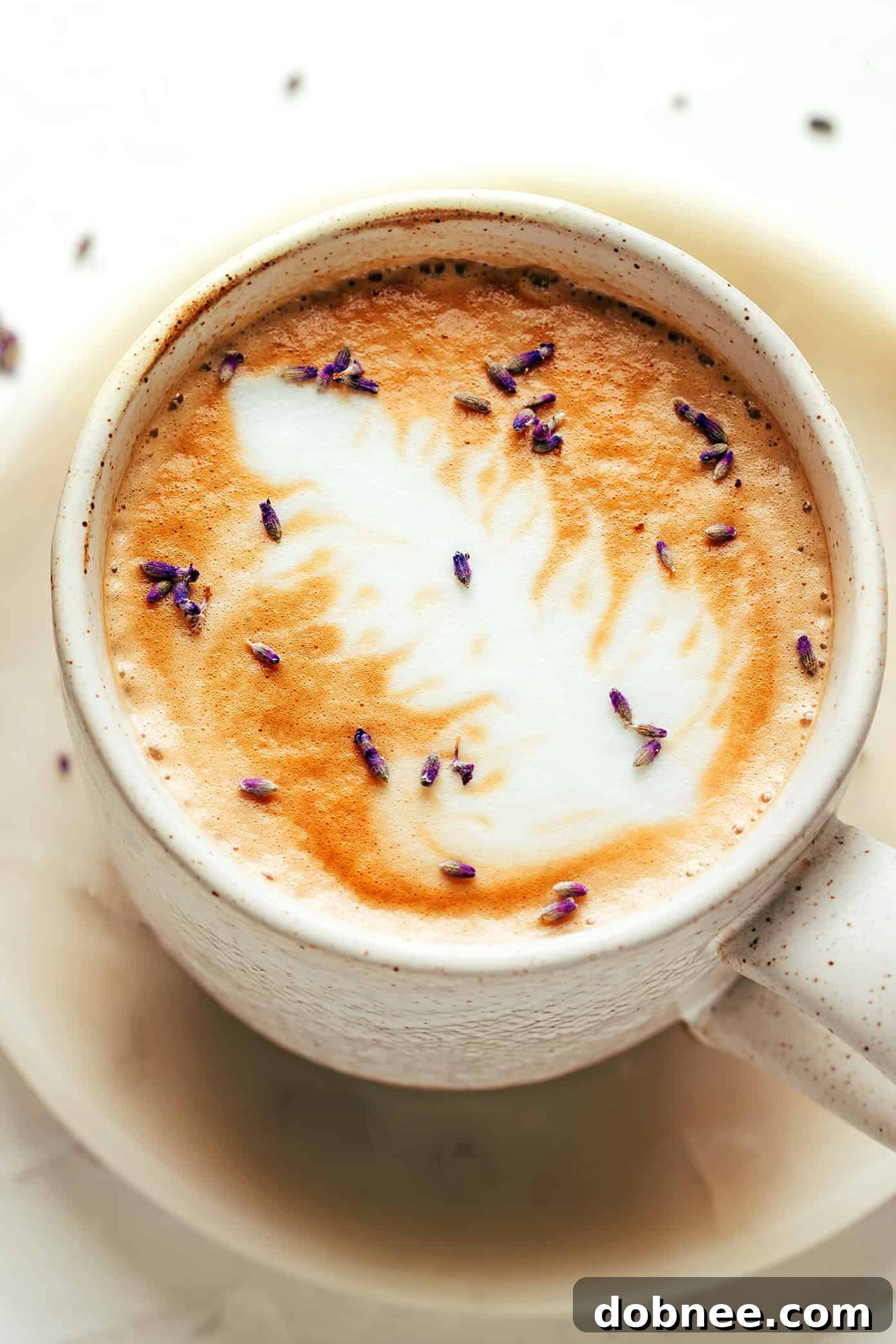 Homemade lavender syrup in a glass bottle with a fresh lavender sprig, ready for use.
