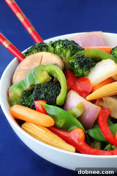 Close-up view of fresh Ginger Vegetable Stir Fry, showcasing the finely grated ginger and the vibrant texture of broccoli, carrots, and bell peppers.