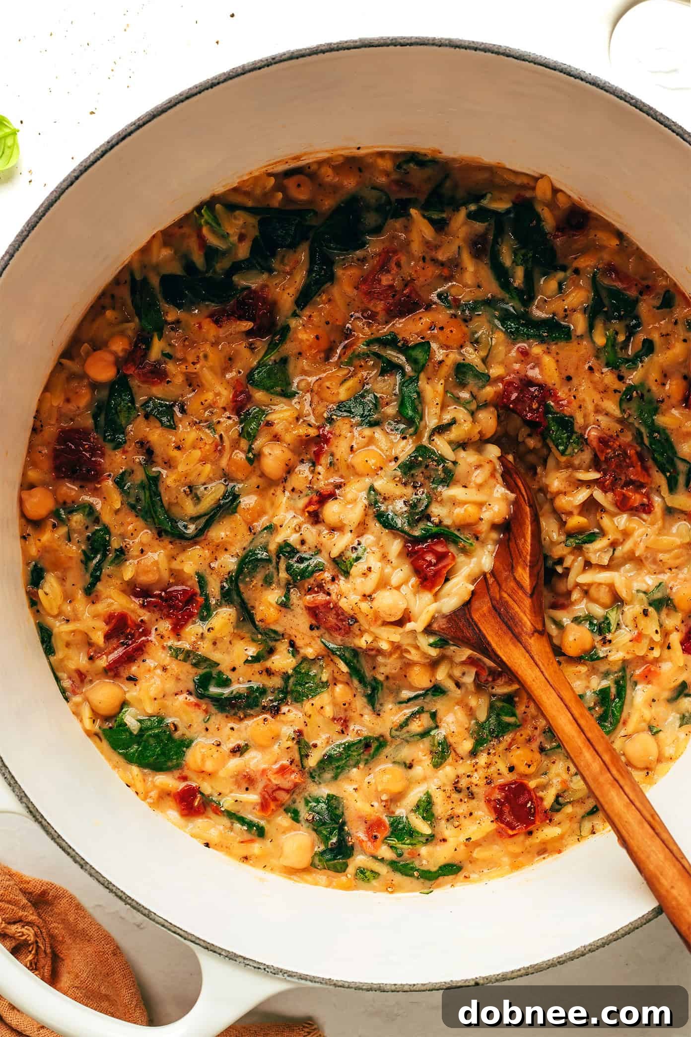 Close-up of Marry Me Chickpeas and Orzo, steaming in a serving bowl