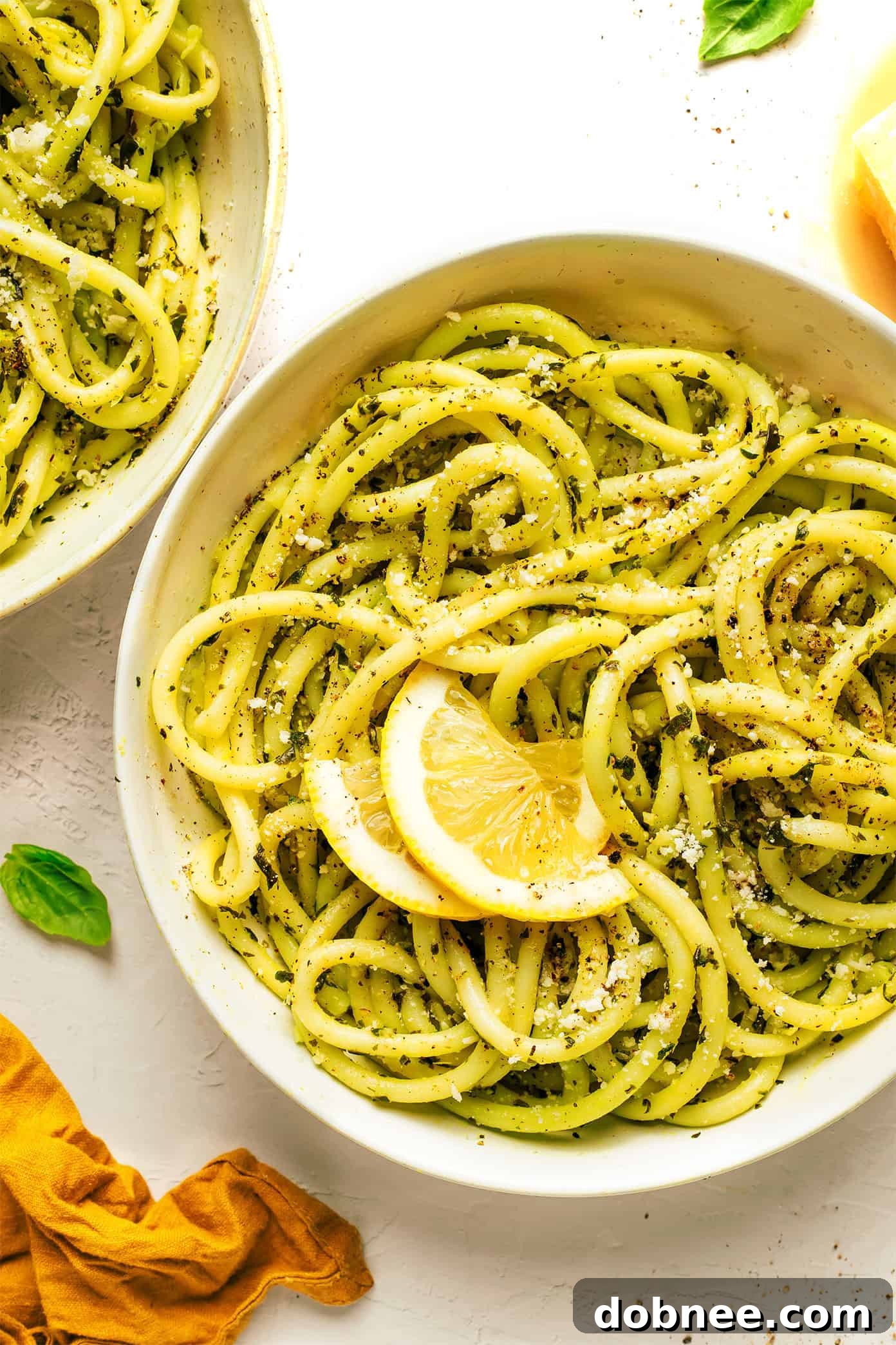 A perfectly portioned bowl of Lemon Basil Butter Pasta, generously topped with fresh Parmesan cheese and a sprig of basil, ready for a delicious meal.
