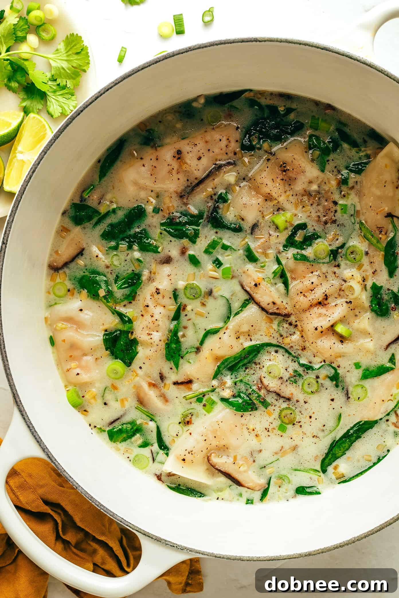 A vibrant bowl of Ginger Coconut Potsticker Soup, ready to be enjoyed