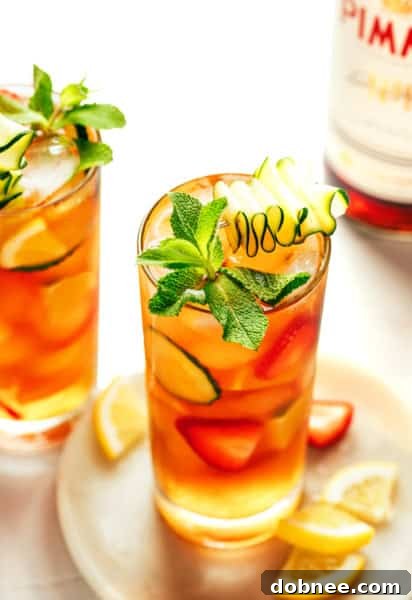 A refreshing Pimm's Cup cocktail with various fruits and mint garnish.